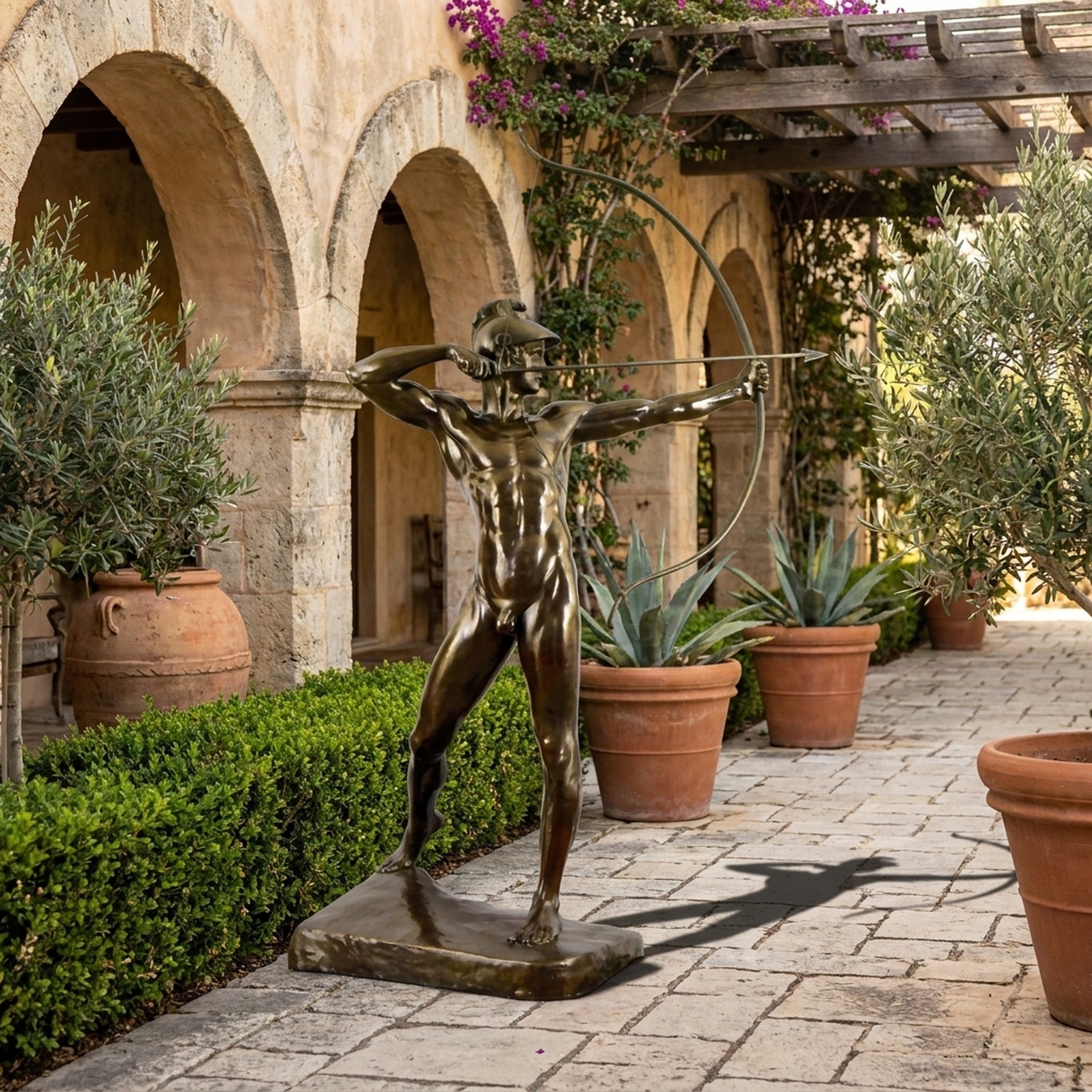 Classical Nude Male Archer Bronze Sculpture by Giant Sculptures at full draw on a Mediterranean courtyard pathway lined with olive trees and terracotta pots.