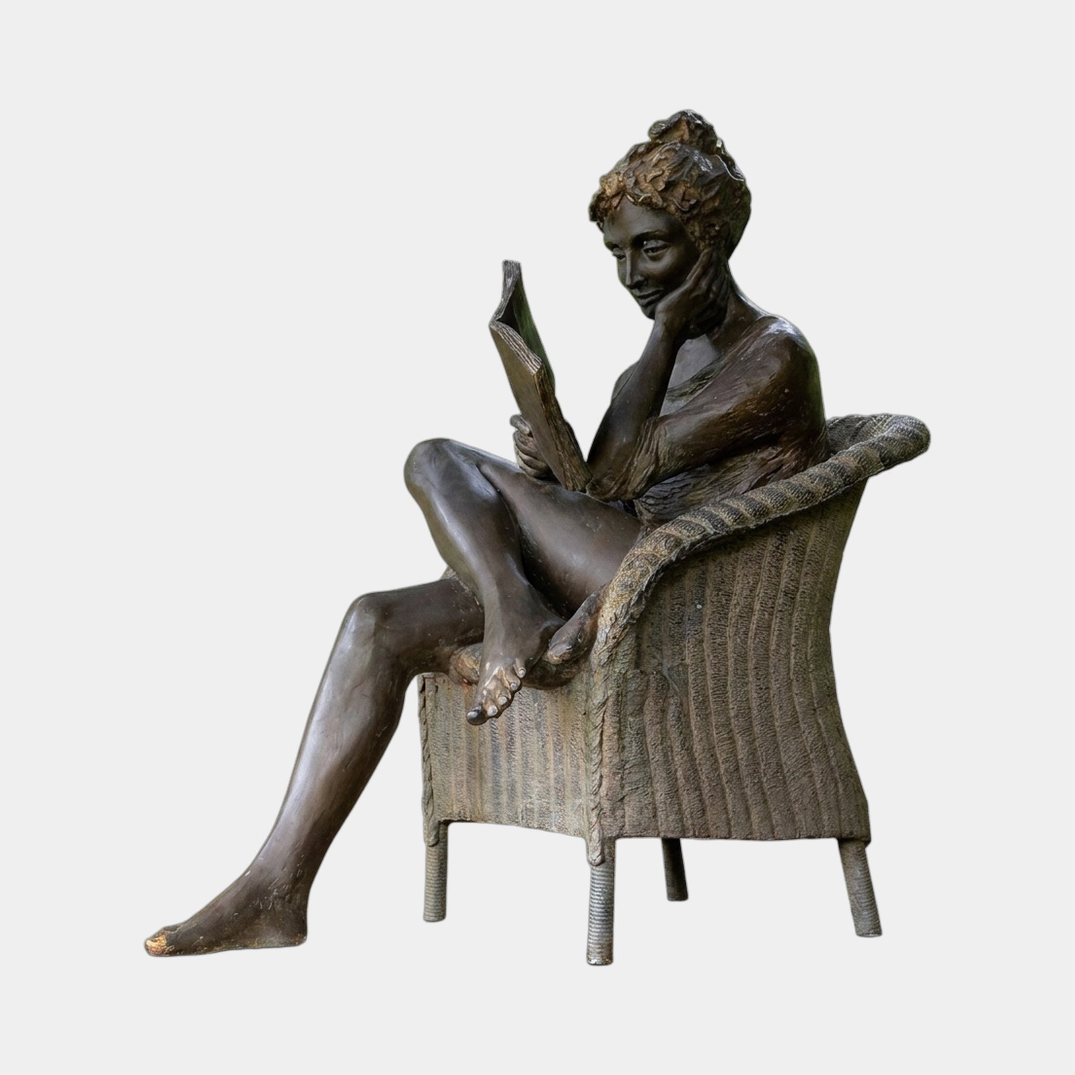 Giant Sculptures Contemporary Reading Woman Bronze Sculpture 150cm, seated in a wicker armchair with leg draped over the armrest, reading a book, warm brown patina.