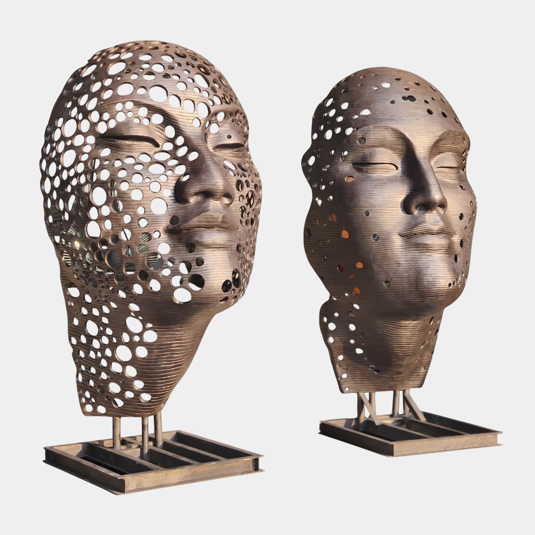 Giant Sculptures Contemporary Perforated Heads Bronze Sculpture 220cm, two closed-eye faces with ribbed layers and circular cutouts on slim pedestal bases.