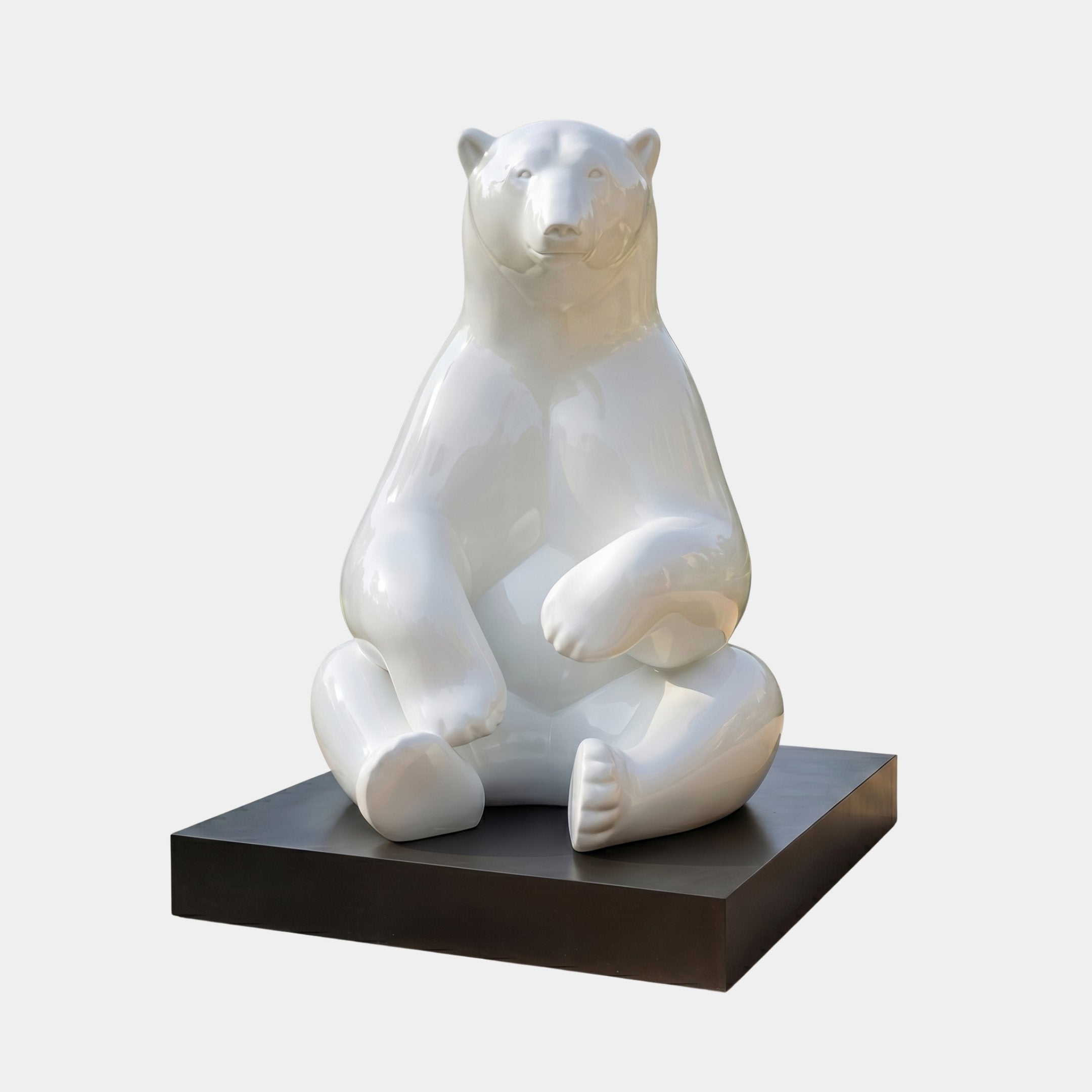 Giant Contemporary Seated Polar Bear Bronze Sculpture in high-gloss white, seated with crossed legs on a black plinth against a plain light background.