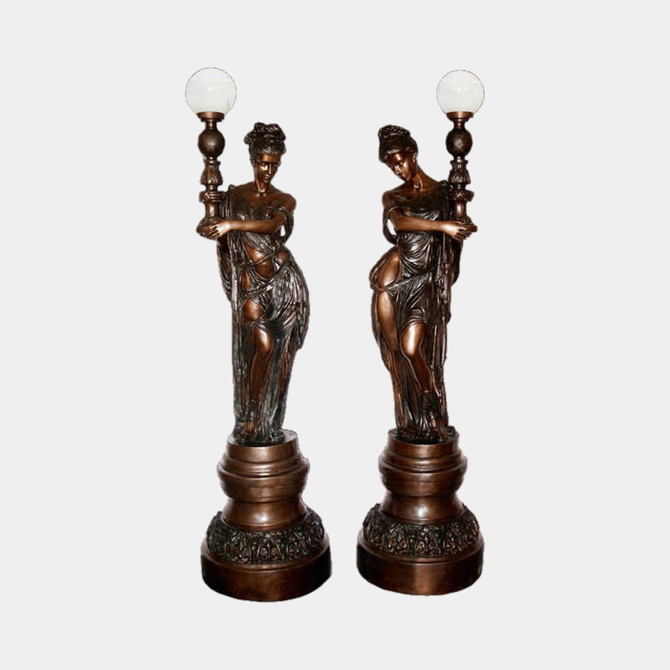 Large Classical Goddess Torchère Bronze Sculpture by Giant Sculptures, a 240cm mirrored pair of draped female figures holding frosted globe lamps on tiered plinths.