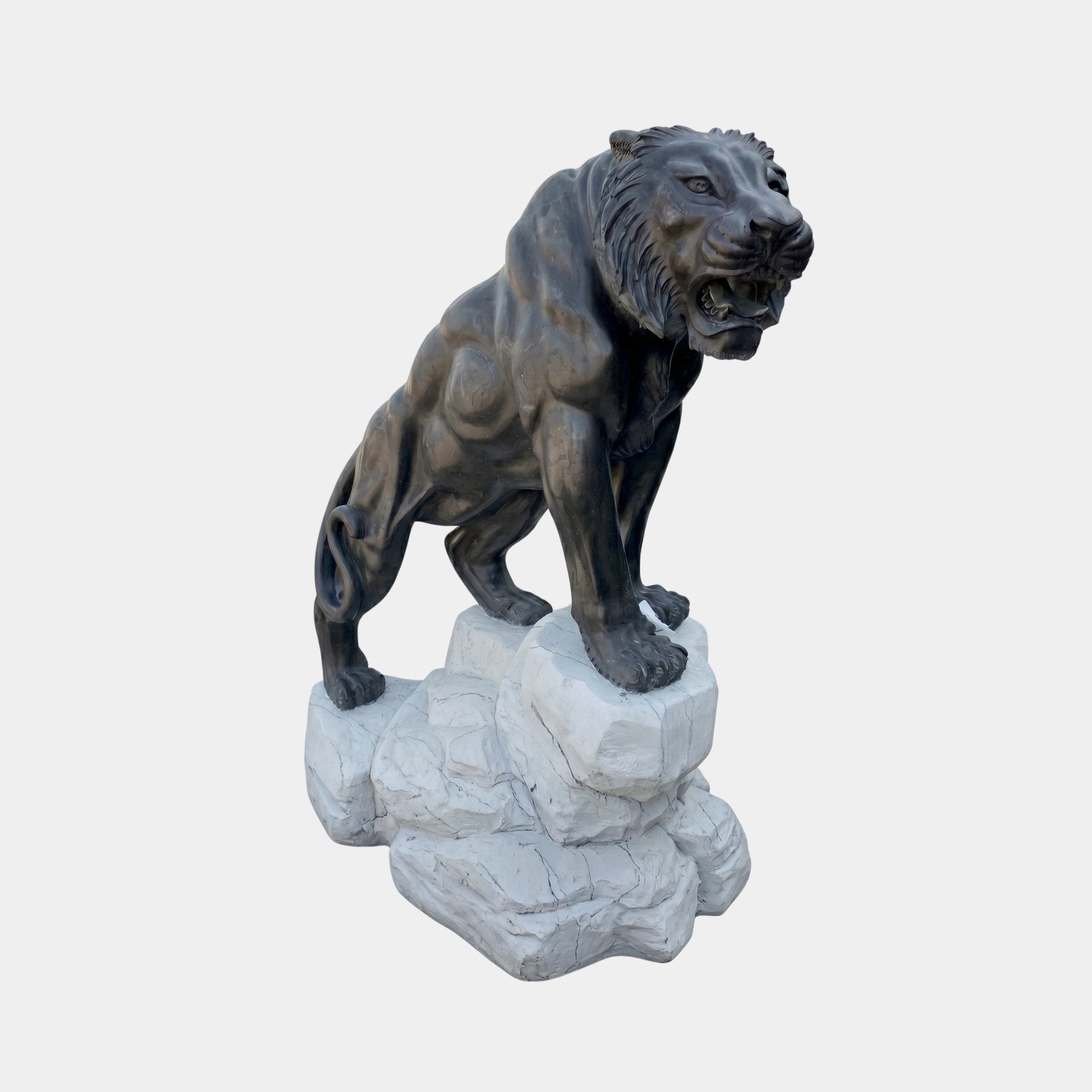 Large Classical Roaring Tiger Bronze Sculpture by Giant Sculptures, dark patina tiger crouching with open snarl on a pale rough marble base, plain background.