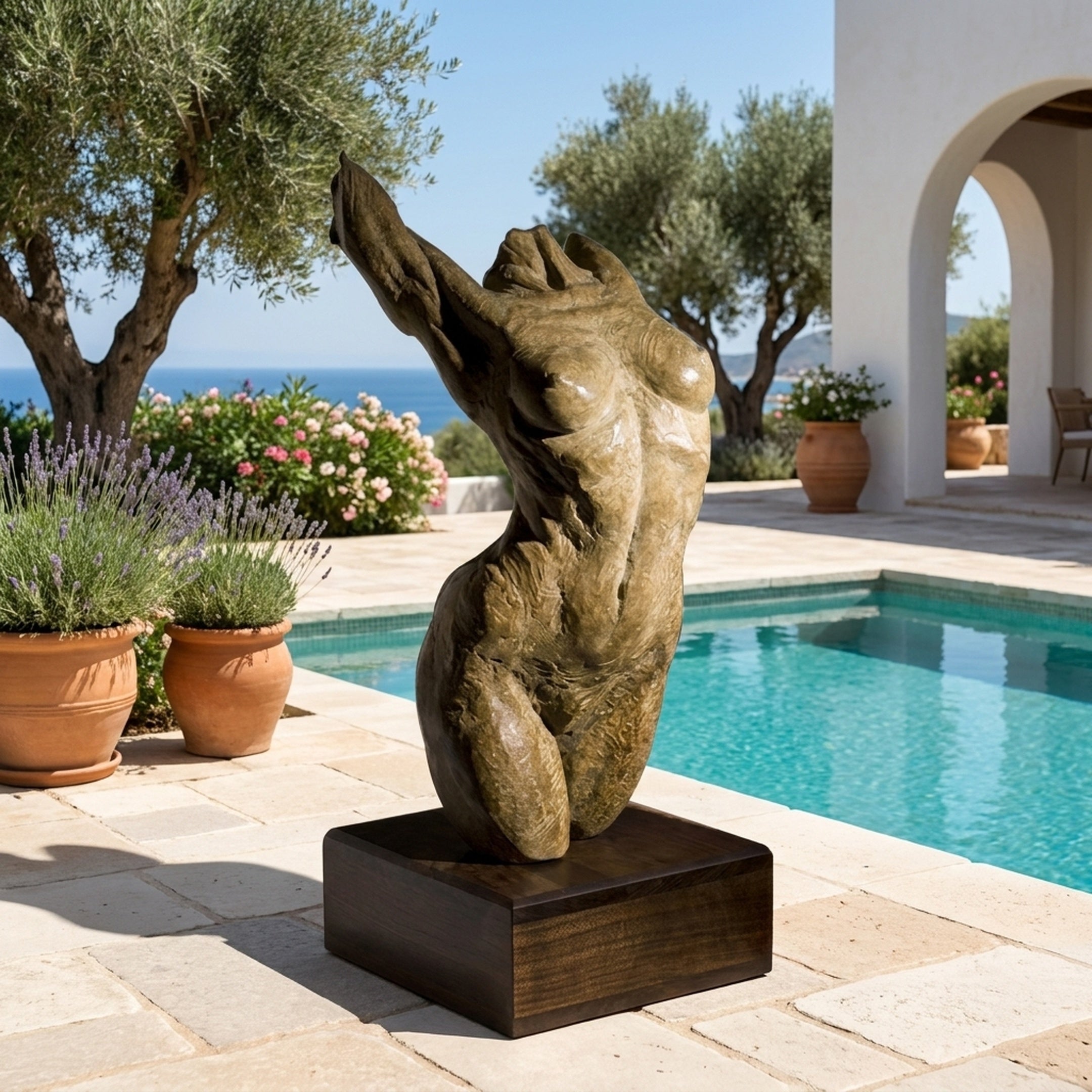 Large Contemporary Abstract Female Torso Bronze Sculpture by Giant Sculptures on a dark plinth beside a pool, with olive trees and sea view behind.