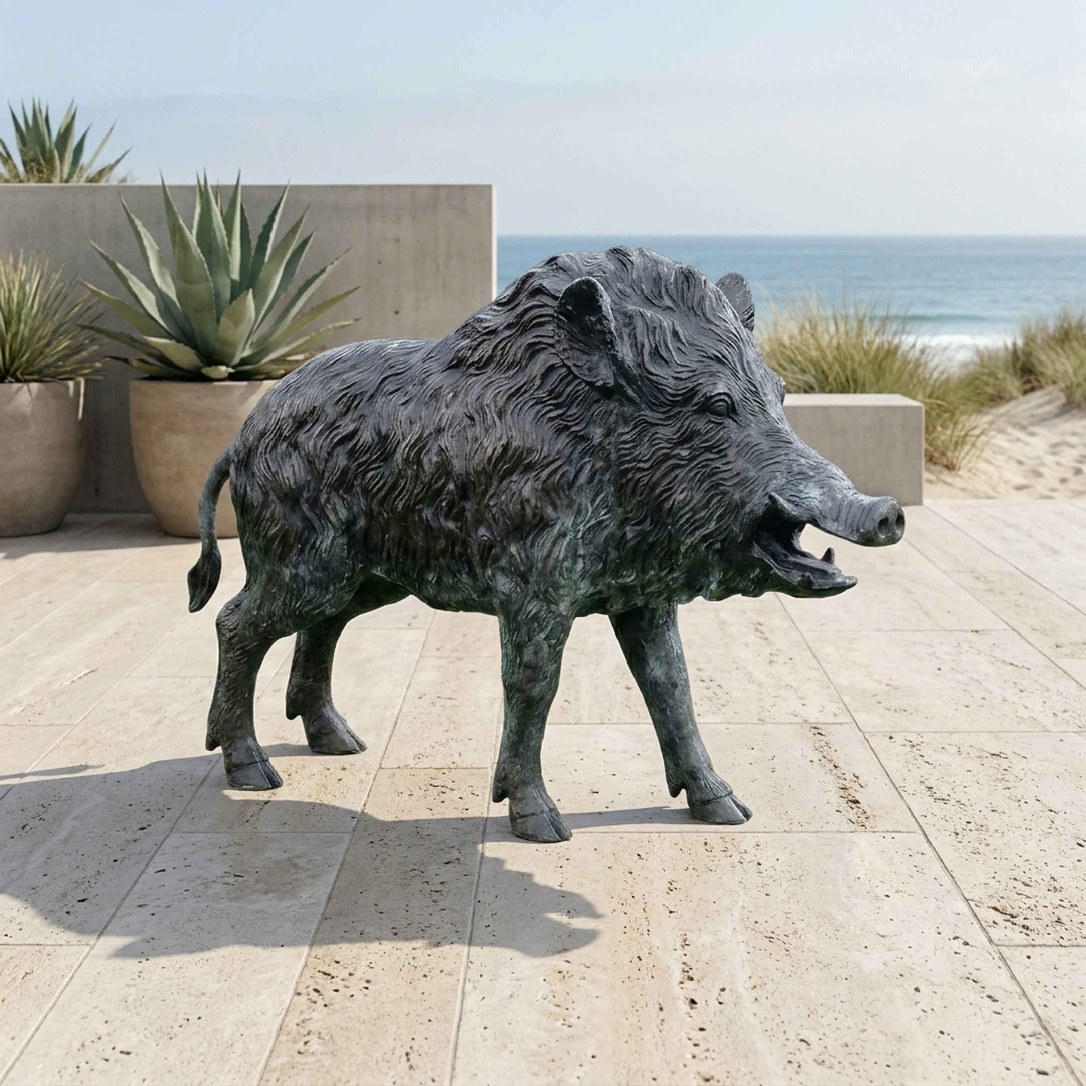 Large Traditional Charging Wild Boar Bronze Sculpture by Giant Sculptures with dark patinated finish, displayed on a coastal stone patio beside agave planters.
