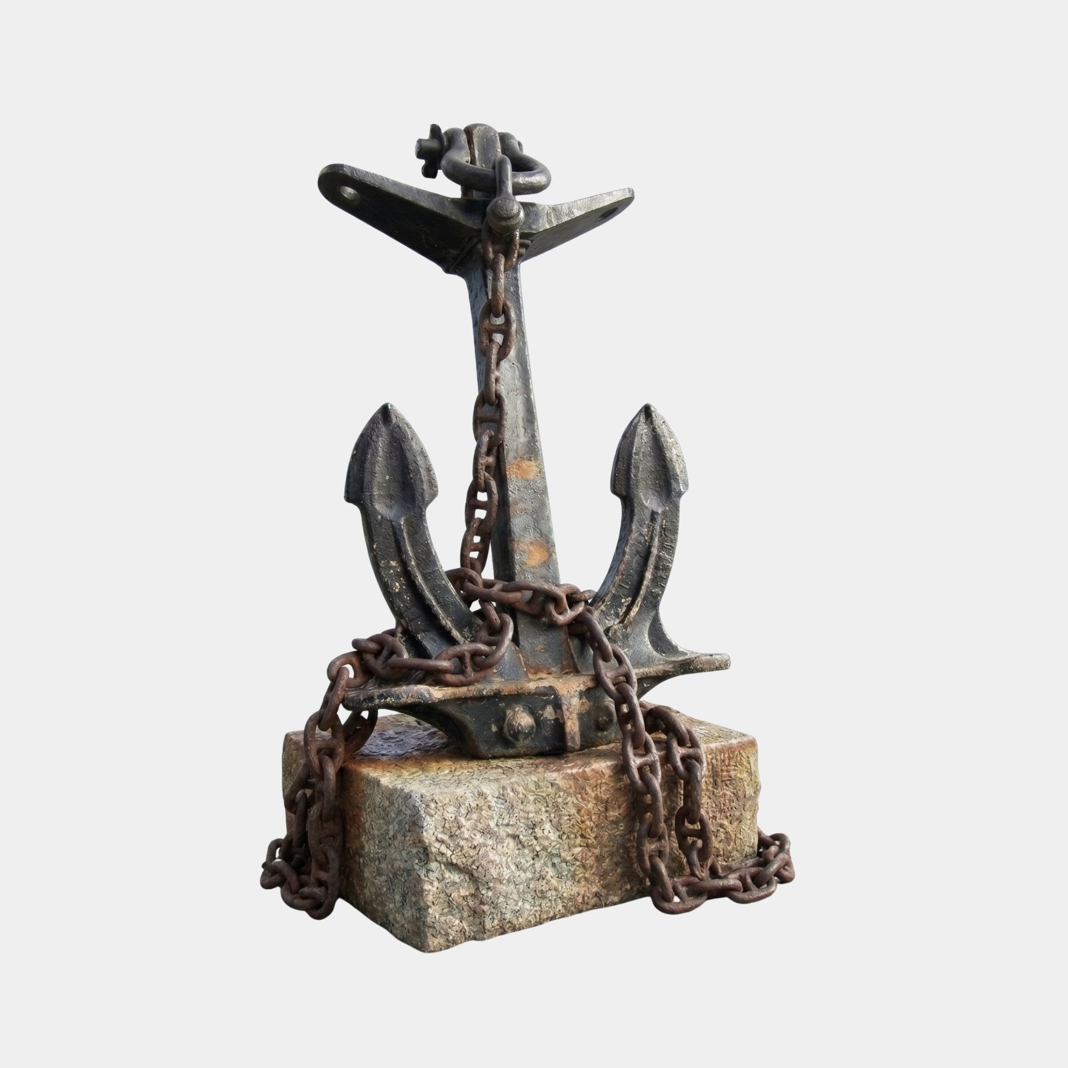 Large Traditional Naval Anchor Bronze Sculpture by Giant Sculptures, dark patinated admiralty-style anchor draped with rusted chain on a stone base, plain background.