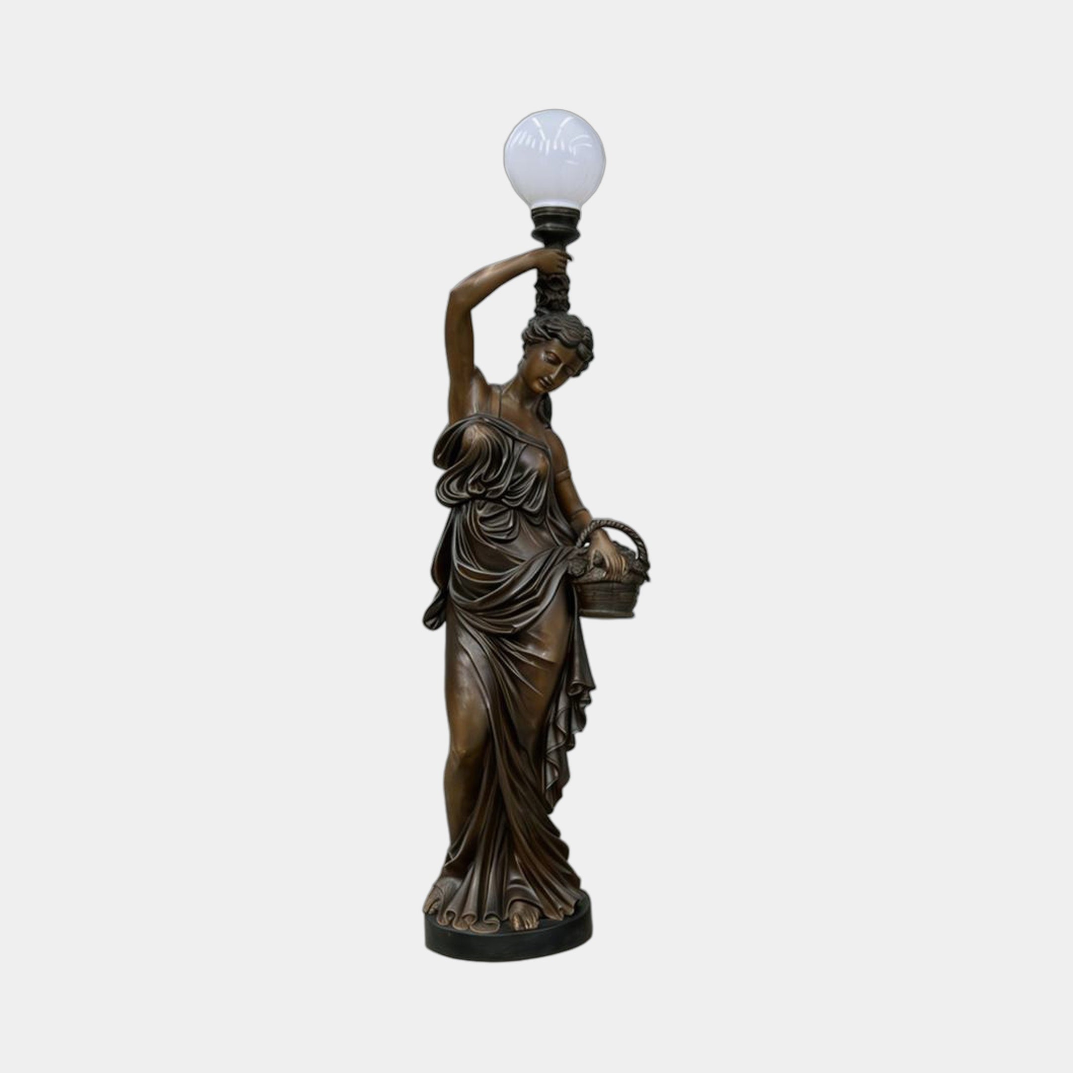 Life-Size Classical Female Figure Bronze Sculpture by Giant Sculptures, 230cm draped goddess holding a frosted globe lamp aloft and a wicker basket.