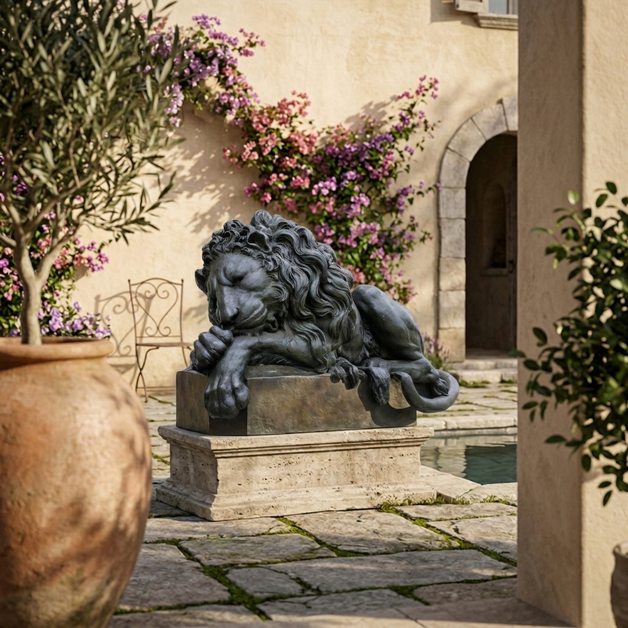 Life-Size Classical Recumbent Lion Bronze Sculpture by Giant Sculptures on a stone plinth in a Mediterranean courtyard with bougainvillea and an olive tree.