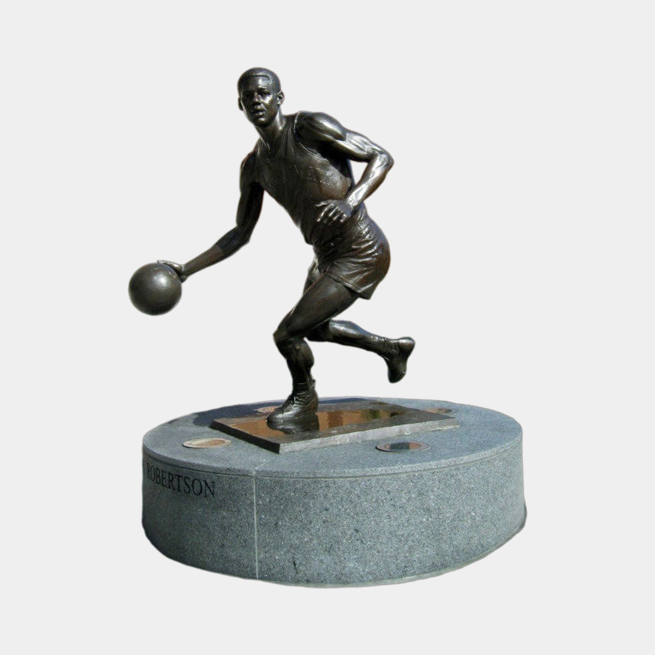 Life-Size Contemporary Basketball Player Bronze Sculpture by Giant Sculptures, shown mid-dribble in dark patina on a round speckled grey granite plinth marked Robertson.