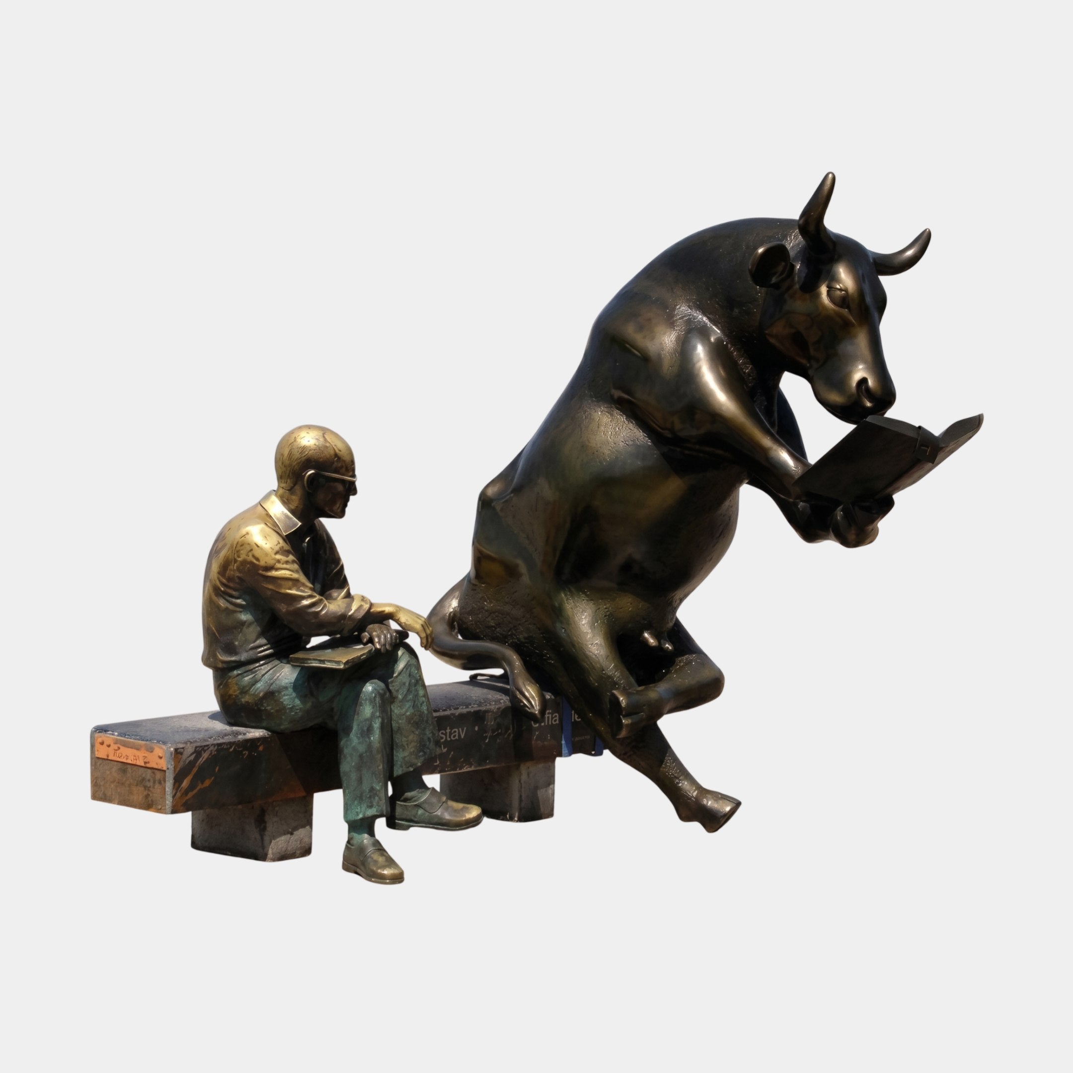 Life-Size Contemporary Bull and Man Reading Bronze Sculpture by Giant Sculptures, showing a dark patinated bull reading a book beside a golden-bronze seated man on a shared bench plinth.
