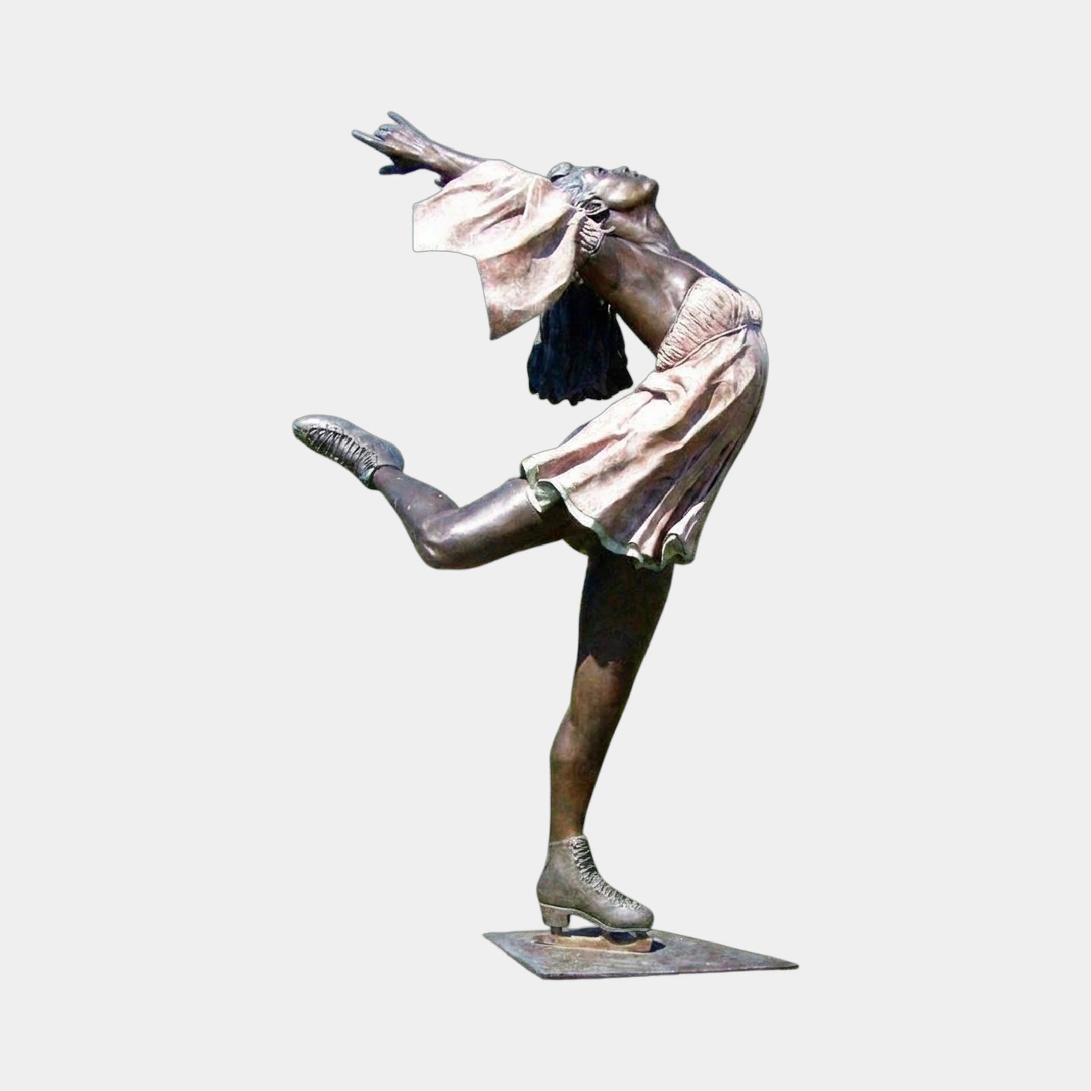 Life-Size Contemporary Female Figure Skater Bronze Sculpture by Giant Sculptures, arched back with arms and leg lifted, warm brown patina, on a low metal base.