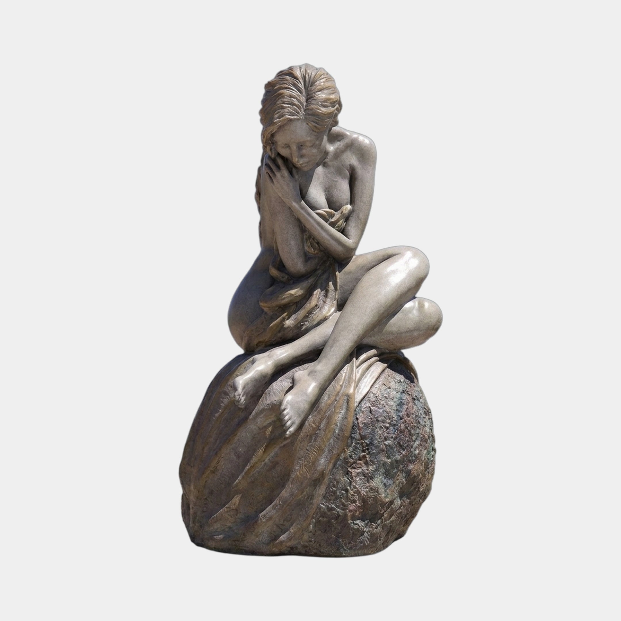 Life-Size Contemporary Seated Nude Female Figure Bronze Sculpture by Giant Sculptures, golden-brown patina, seated cross-legged on a granite boulder, plain background.