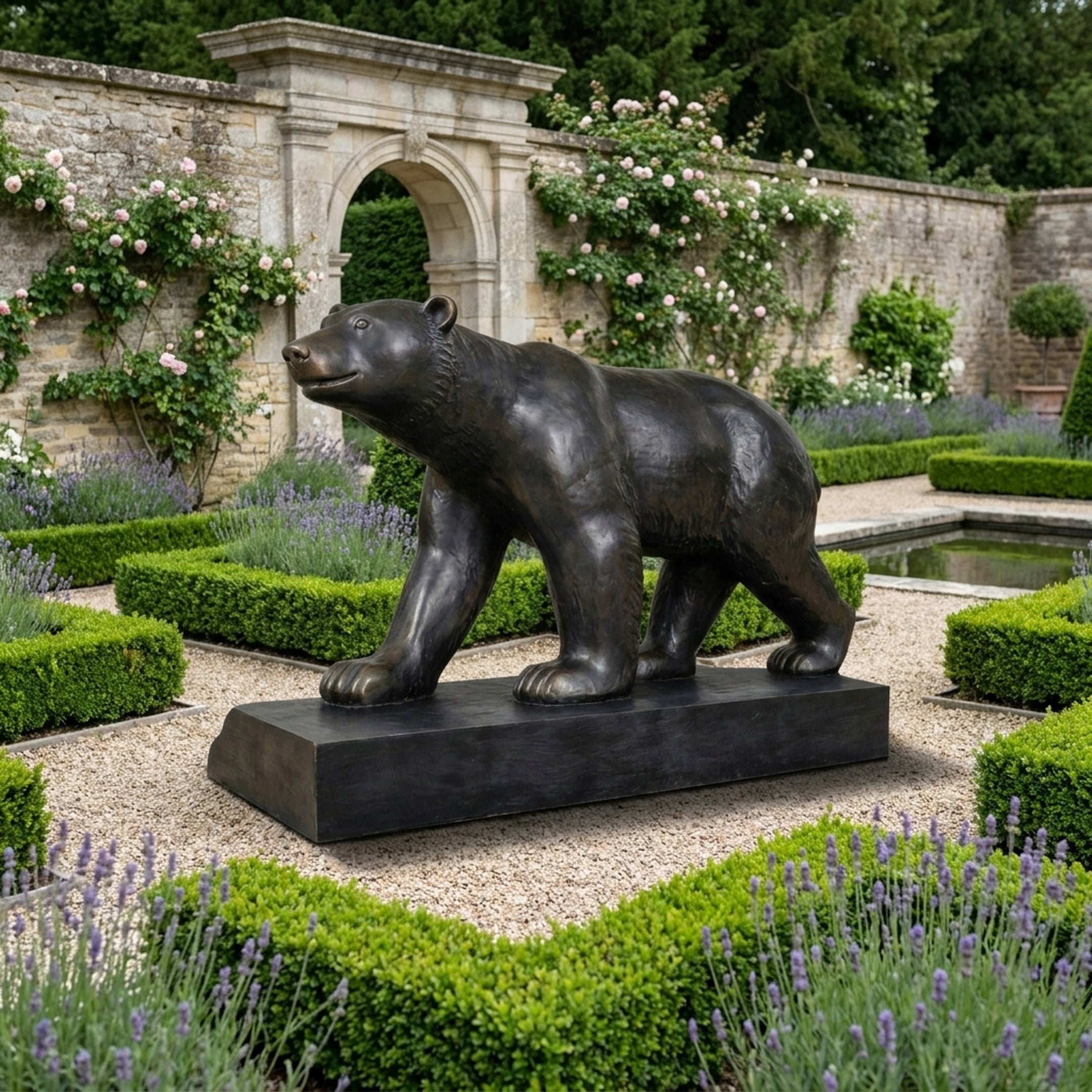 Life-Size Contemporary Walking Bear Bronze Sculpture by Giant Sculptures, dark patina, on a rectangular plinth in a walled garden with lavender and roses.