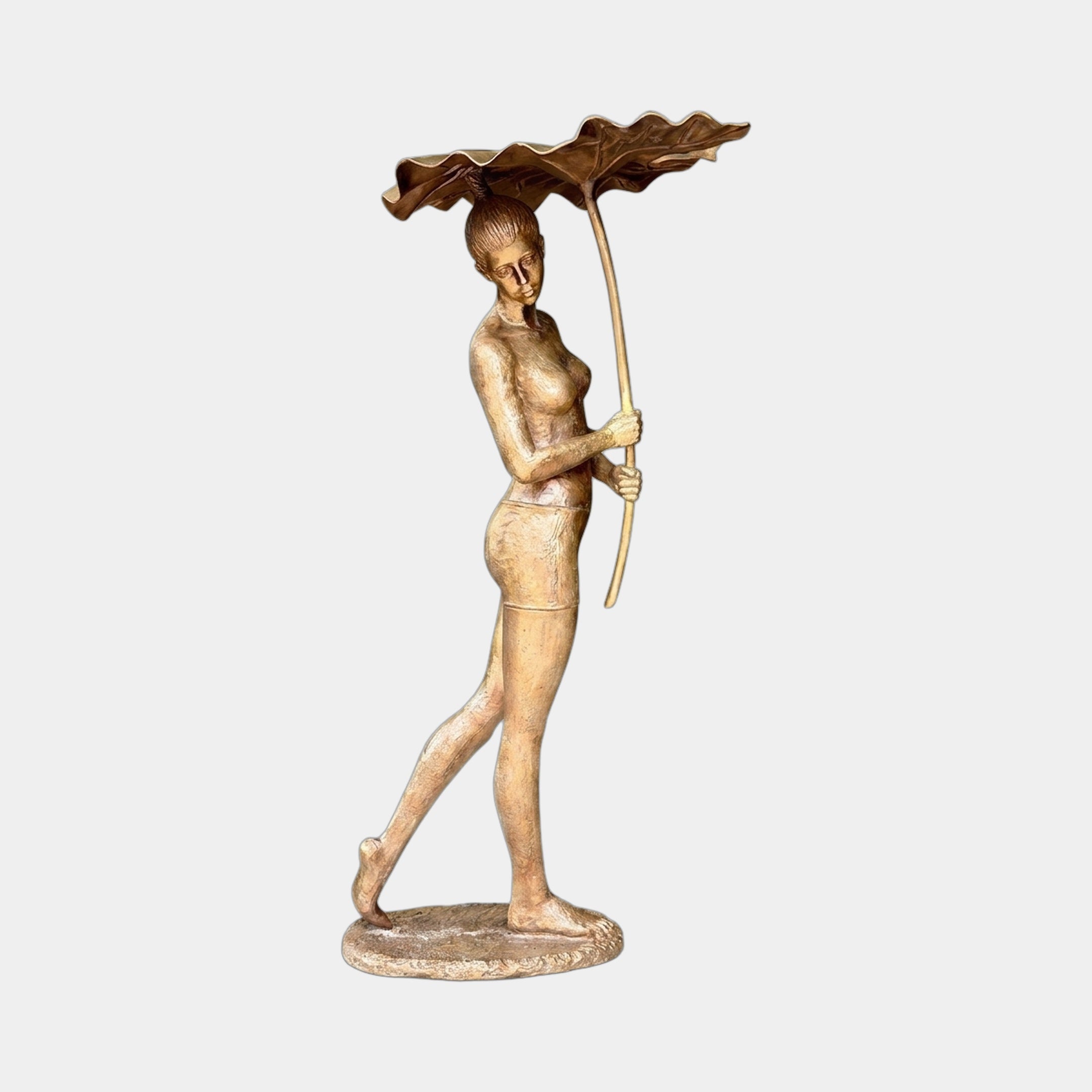 Life-Size Contemporary Walking Woman Bronze Fountain by Giant Sculptures, 190cm, depicting a striding female figure holding a tall lotus stem with leaf canopy overhead.