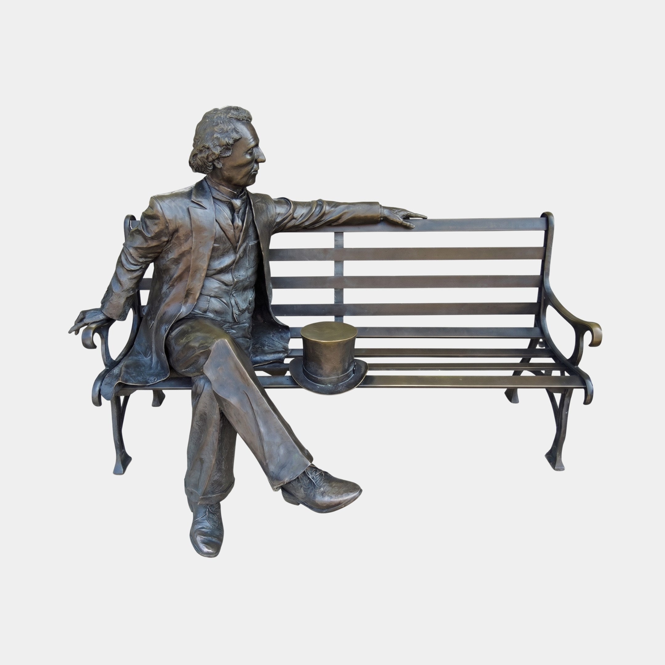 Life-Size Traditional Seated Gentleman Bronze Sculpture by Giant Sculptures, a Victorian figure with crossed legs and top hat resting on the bench beside him.