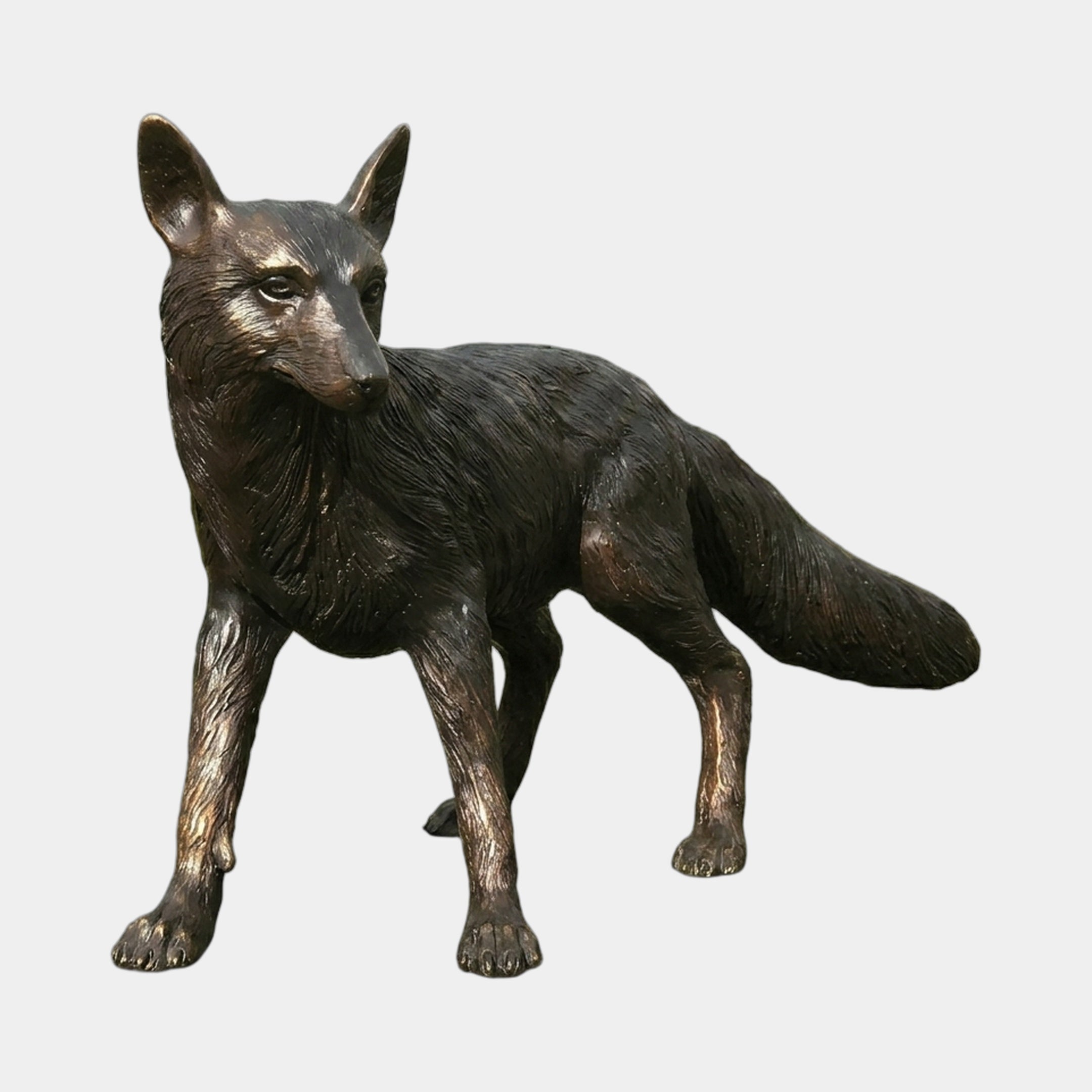 Life-Size Traditional Standing Fox Bronze Sculpture by Giant Sculptures, shown in side view with alert ears and bushy tail, dark patina with copper highlights on plain background.