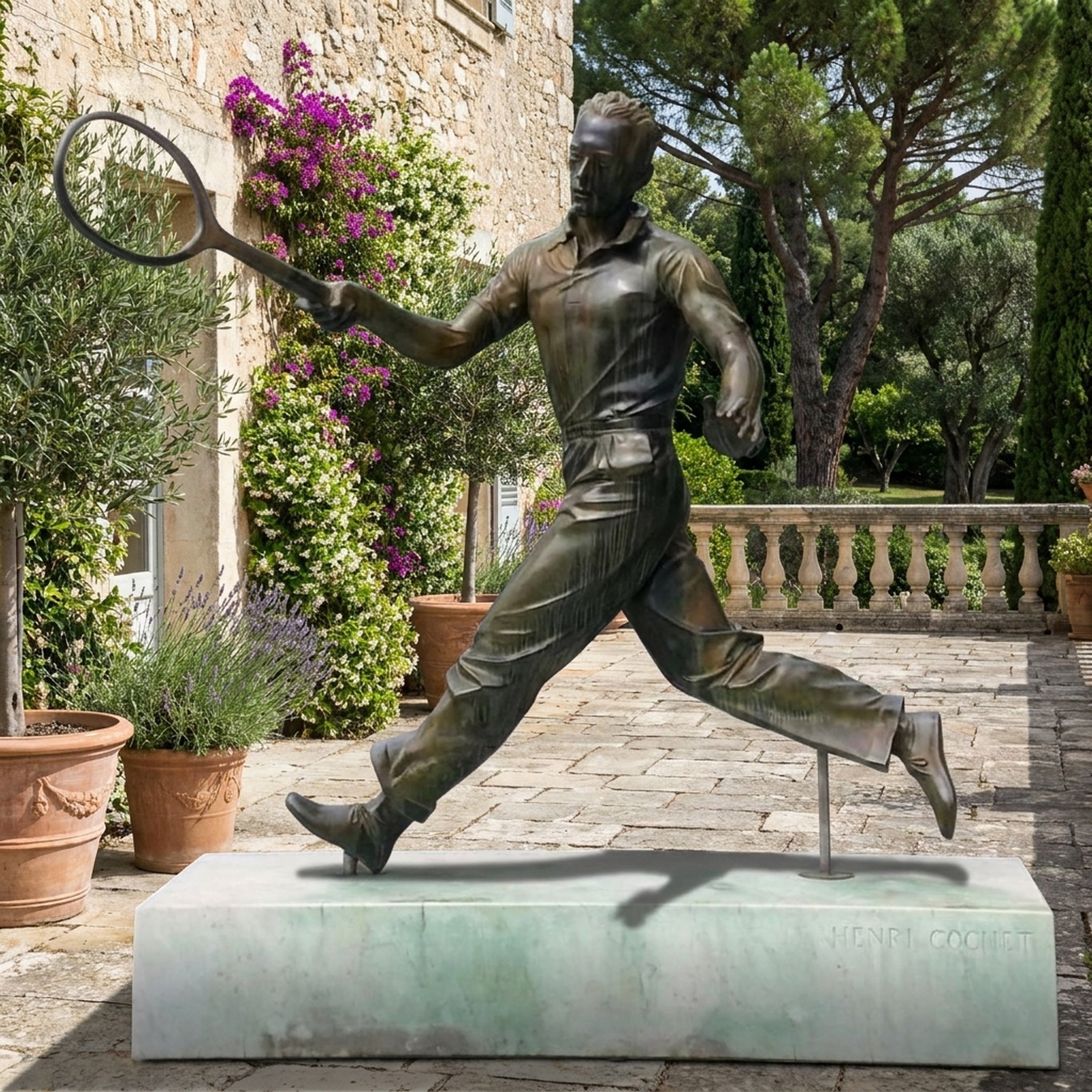 Life-Size Traditional Tennis Player Bronze Statue by Giant Sculptures, mid-stride forehand on a pale marble plinth engraved Henri Cochet, on a stone terrace.