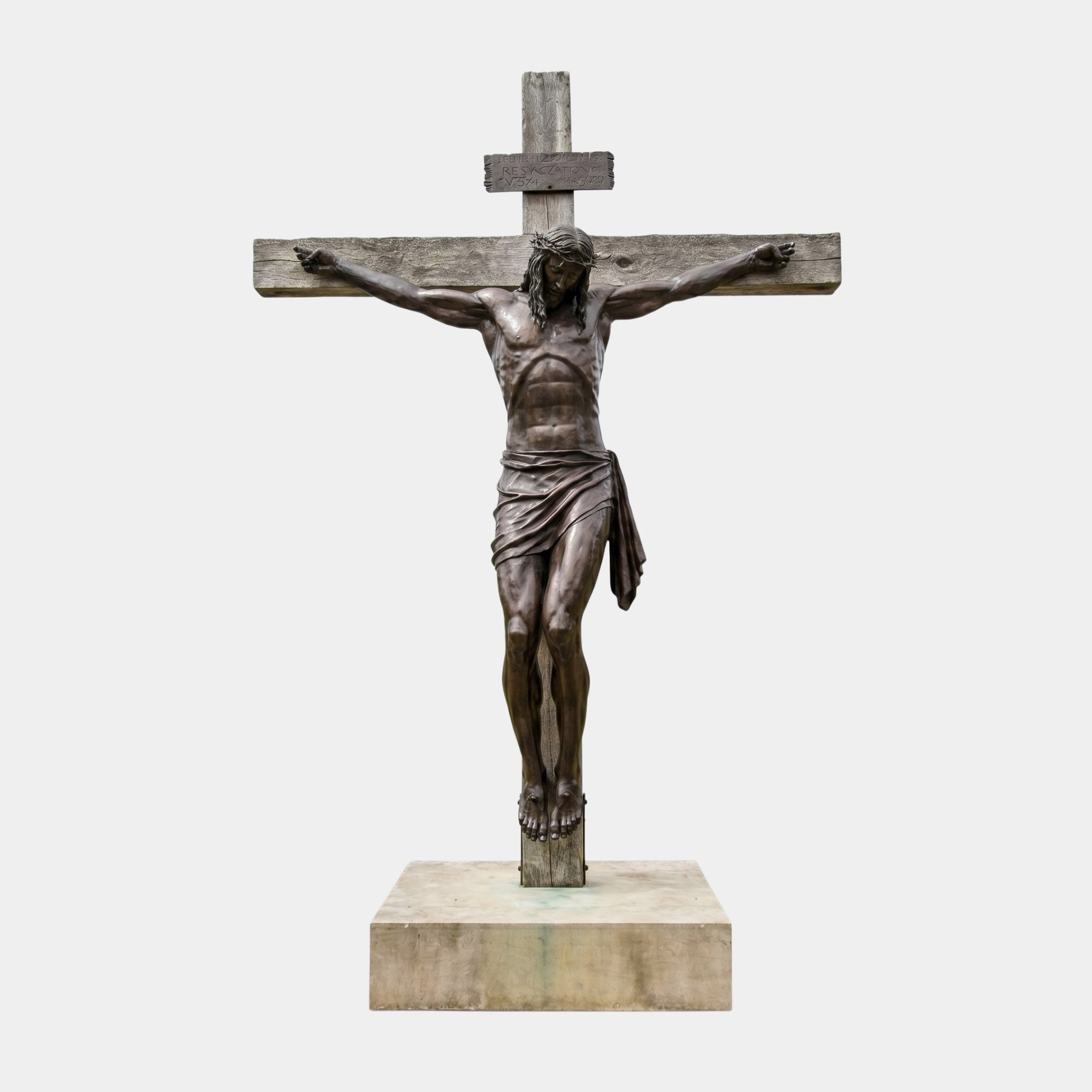Monumental Classical Crucified Christ Bronze Sculpture by Giant Sculptures, dark patina figure on weathered wooden cross with INRI tablet, stone base, 500cm.