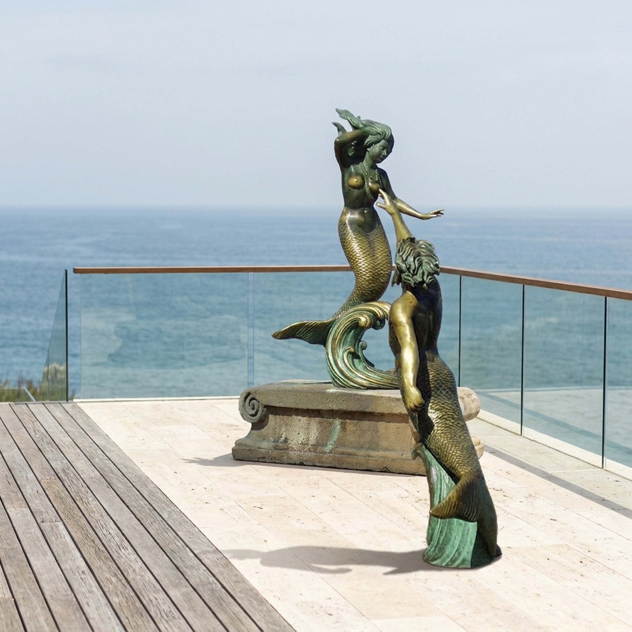 Giant Sculptures Monumental Classical Dual Mermaid Bronze Sculpture 380cm with golden-bronze and green patina on a stone plinth, displayed on an oceanfront terrace.