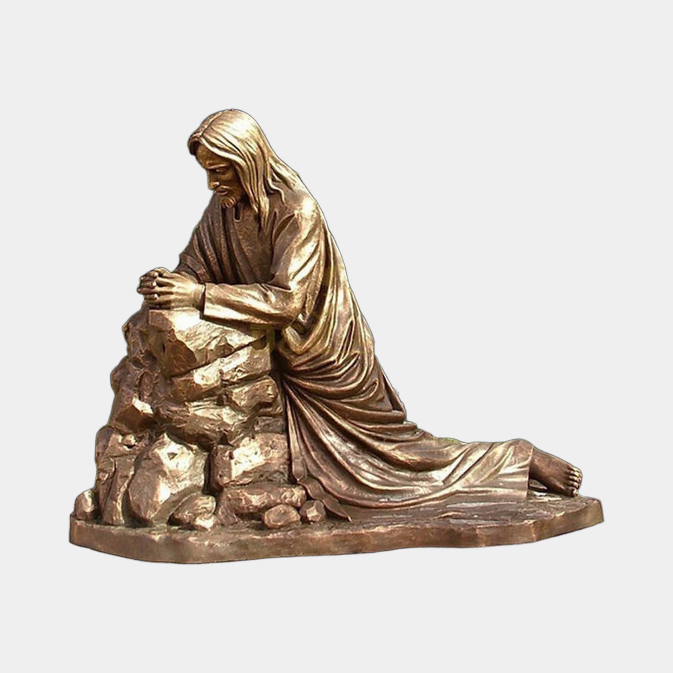 Giant Sculptures' 250cm Monumental Classical Kneeling Christ in Prayer Bronze Sculpture in warm gold-bronze, hands resting on a rocky outcrop, side view.