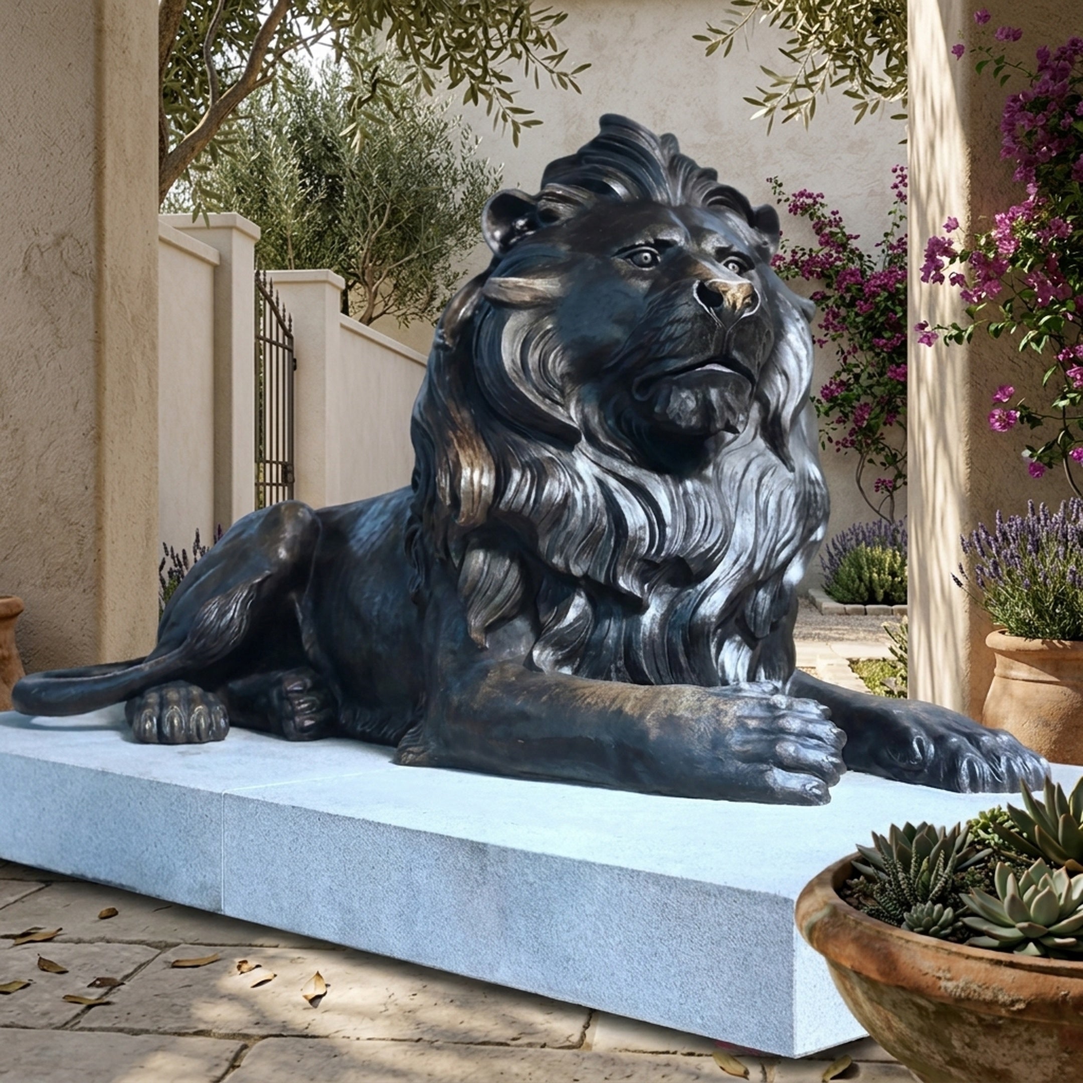 Monumental Classical Recumbent Lion Bronze Sculpture by Giant Sculptures in dark antique patina on a light granite plinth in a sunlit Mediterranean courtyard.