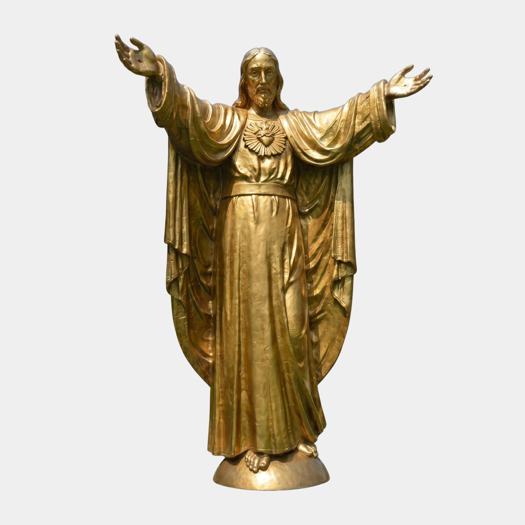 Monumental Classical Sacred Heart Jesus Bronze Statue by Giant Sculptures in gilded gold finish, arms outstretched in blessing, shown on a plain grey background.