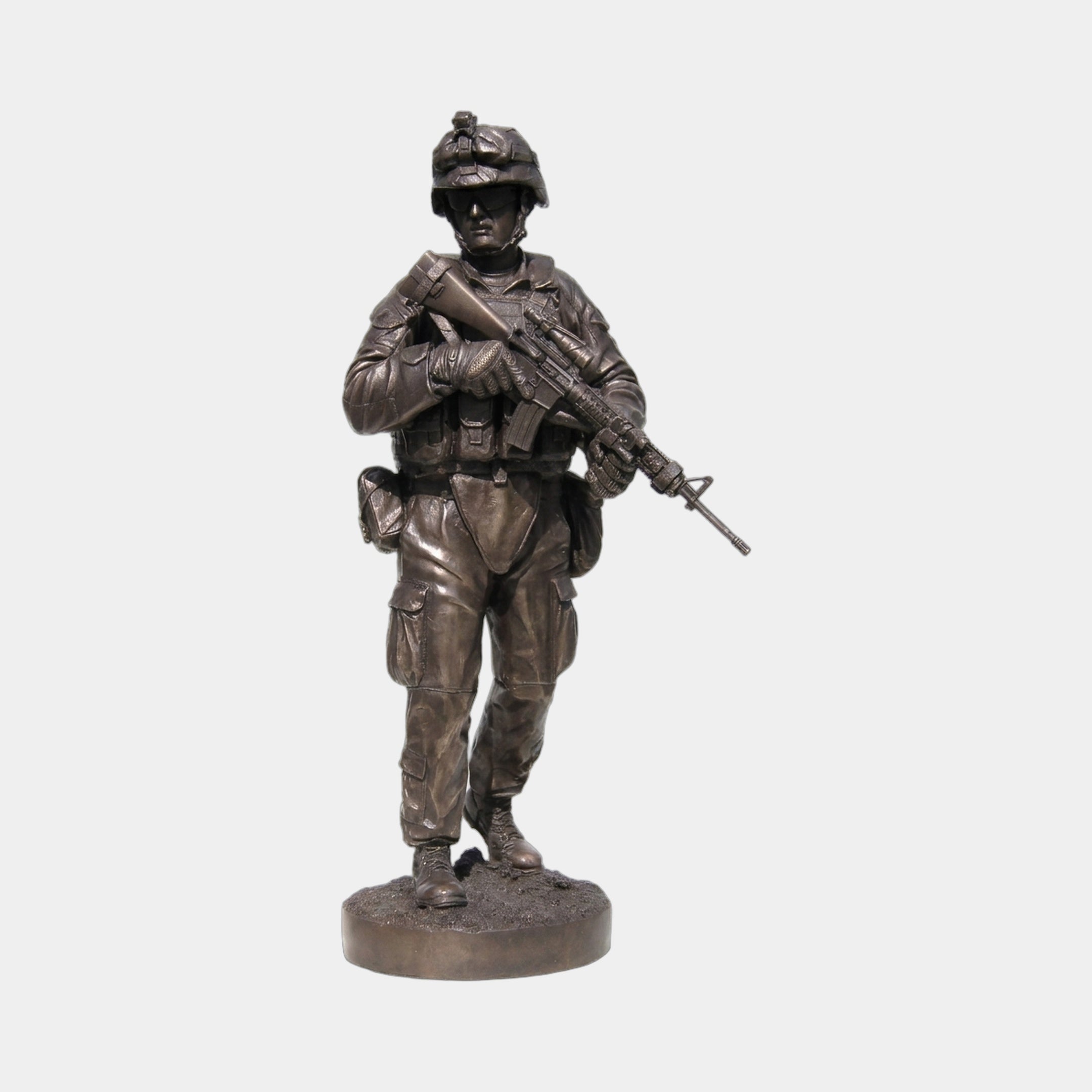 Monumental Contemporary Combat Soldier Bronze Statue by Giant Sculptures, front view of an armed infantryman in helmet and gear on a round base, plain background.