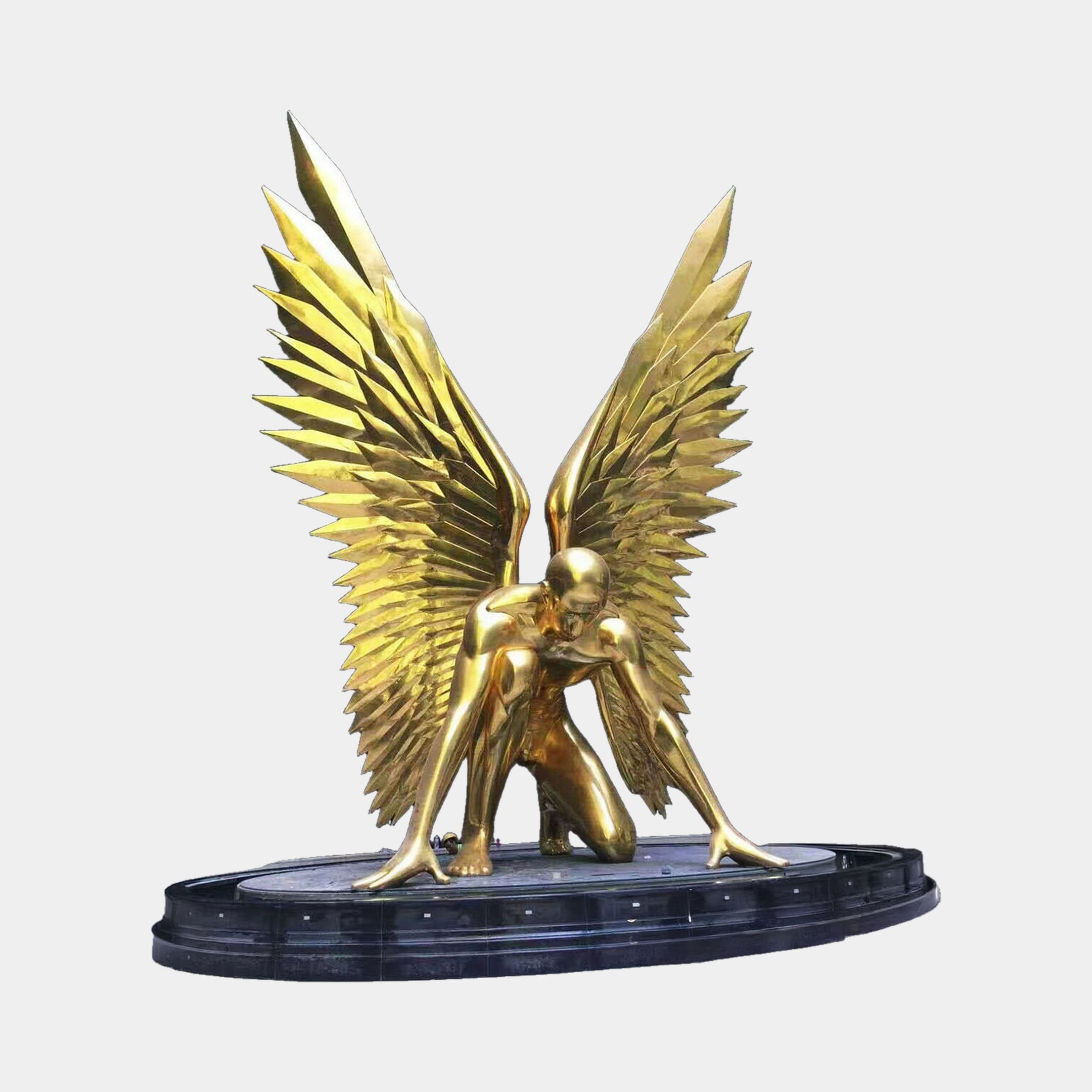 Monumental Contemporary Crouching Angel Bronze Sculpture in polished gold by Giant Sculptures, kneeling figure with vast upswept wings on a dark oval plinth.