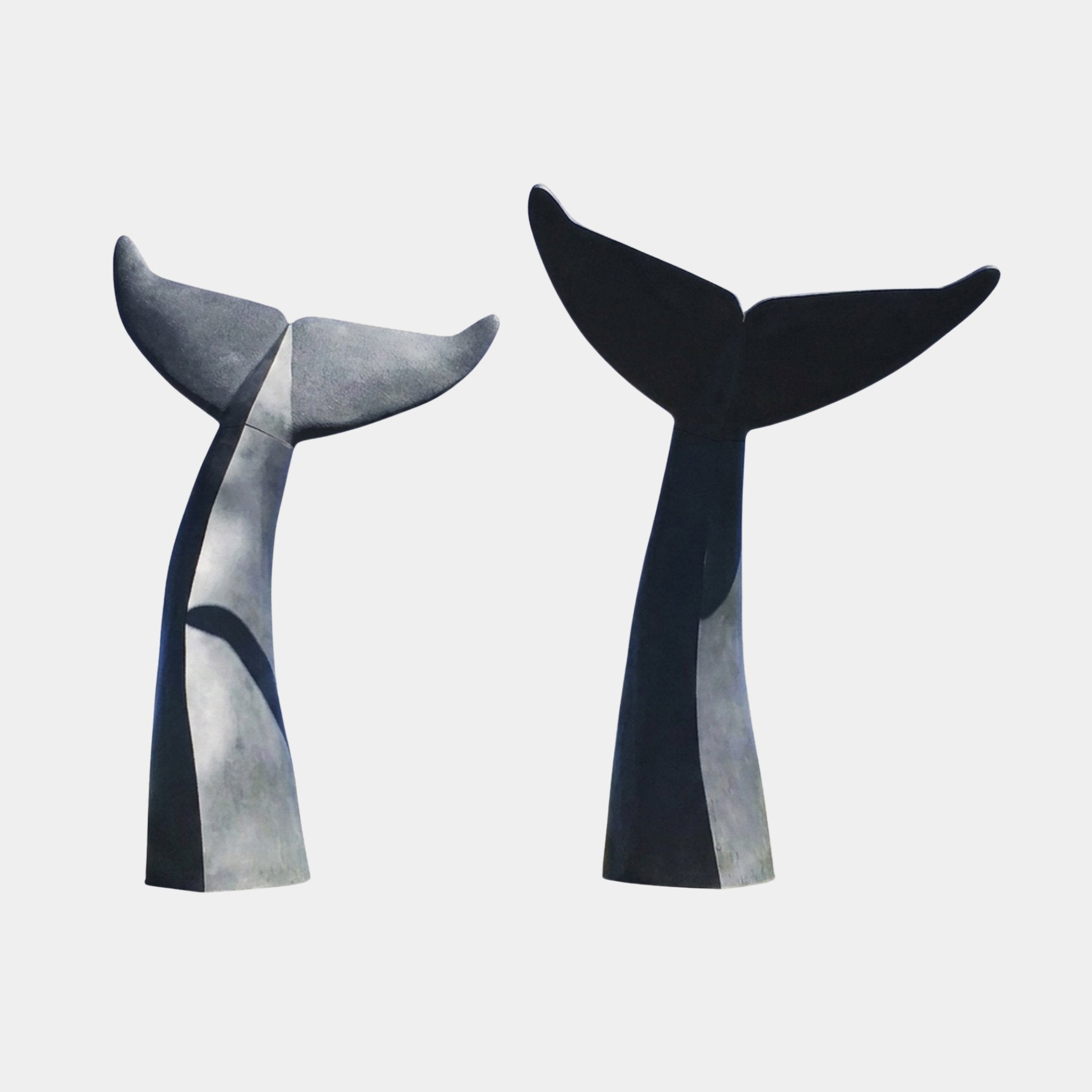 Monumental Paired Whale Tail Bronze Sculpture by Giant Sculptures, two upright fluked tails in near-black patina angled toward each other on a plain background.