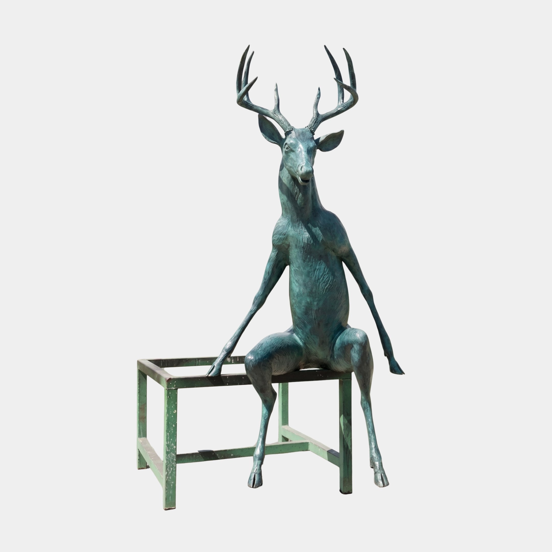 Monumental Contemporary Seated Stag Bronze Sculpture by Giant Sculptures, 250cm, verdigris patina, anthropomorphic seated pose on a green stand, plain background.