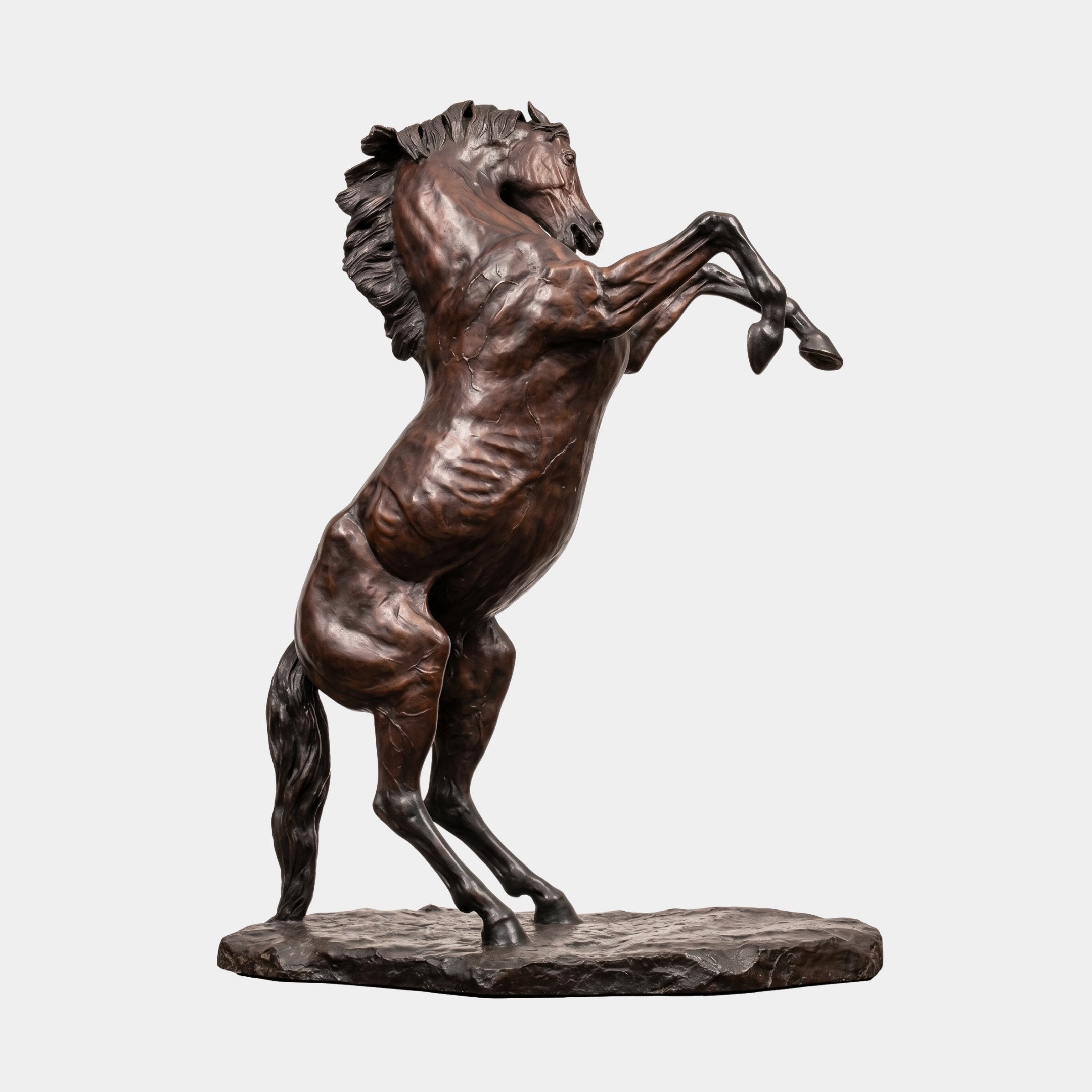 Giant Sculptures Monumental Rearing Horse Bronze Sculpture 210cm shown side-on with reddish-brown patina, flowing mane and tail, on a rough stone base.