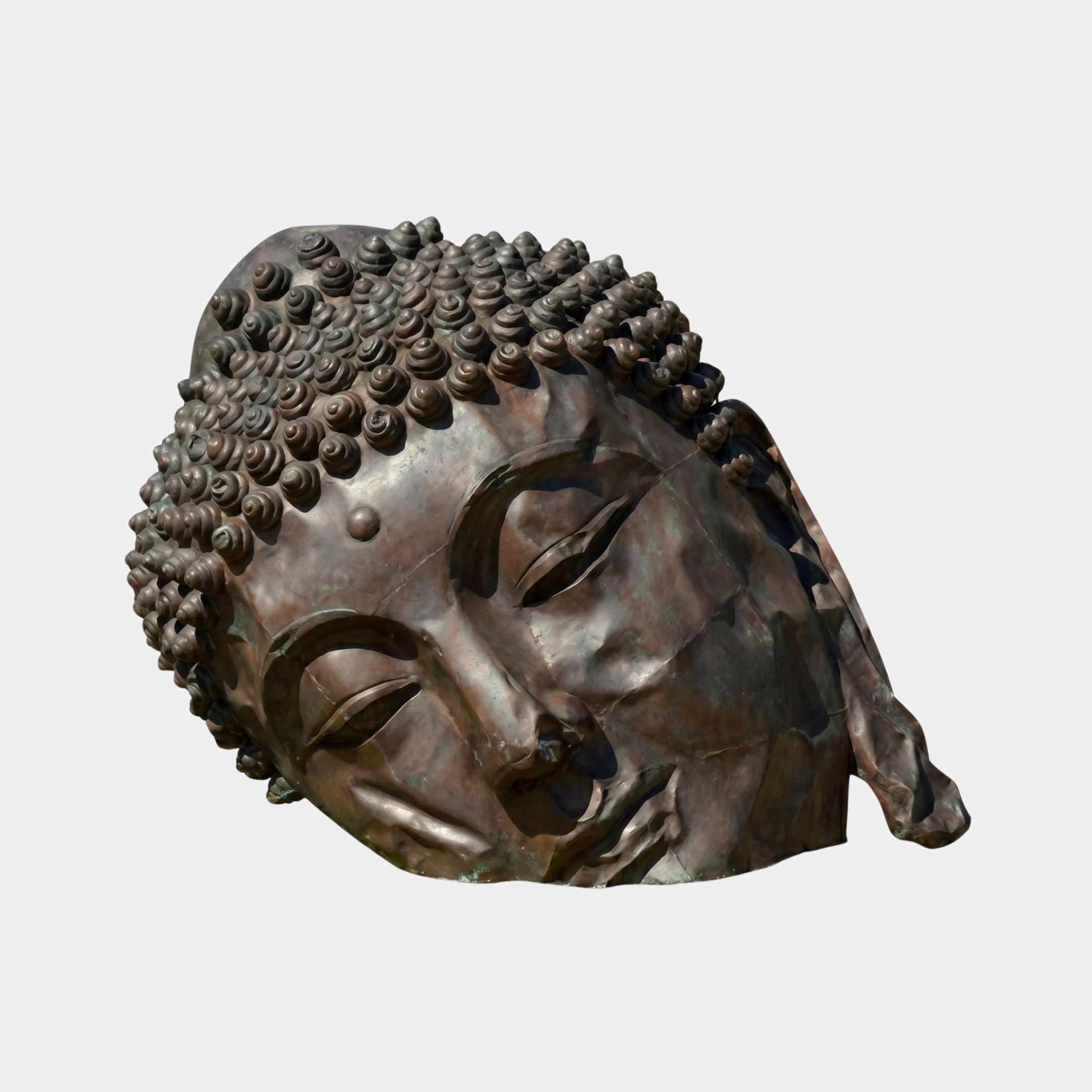 Monumental Traditional Buddha Head Bronze Sculpture by Giant Sculptures, 150cm, shown reclining with downcast eyes and spiral ushnisha curls on a plain background.