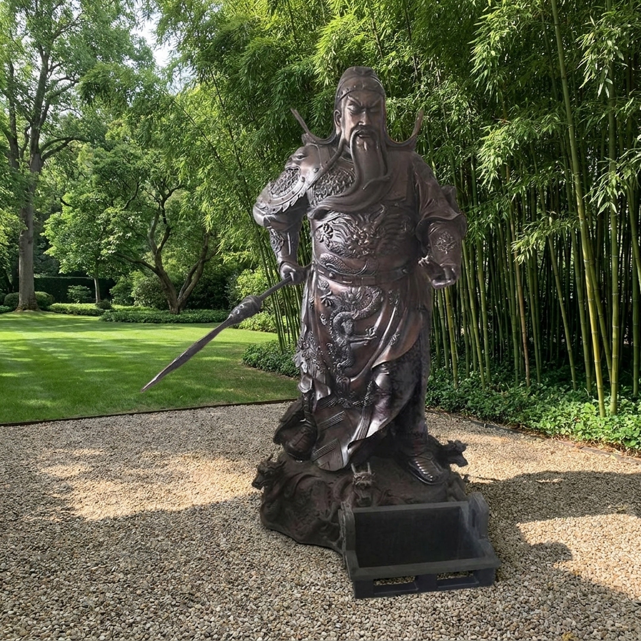 Monumental Traditional Guan Gong Warrior Bronze Statue by Giant Sculptures displayed on gravel in a garden with bamboo and trees, holding a guandao polearm.
