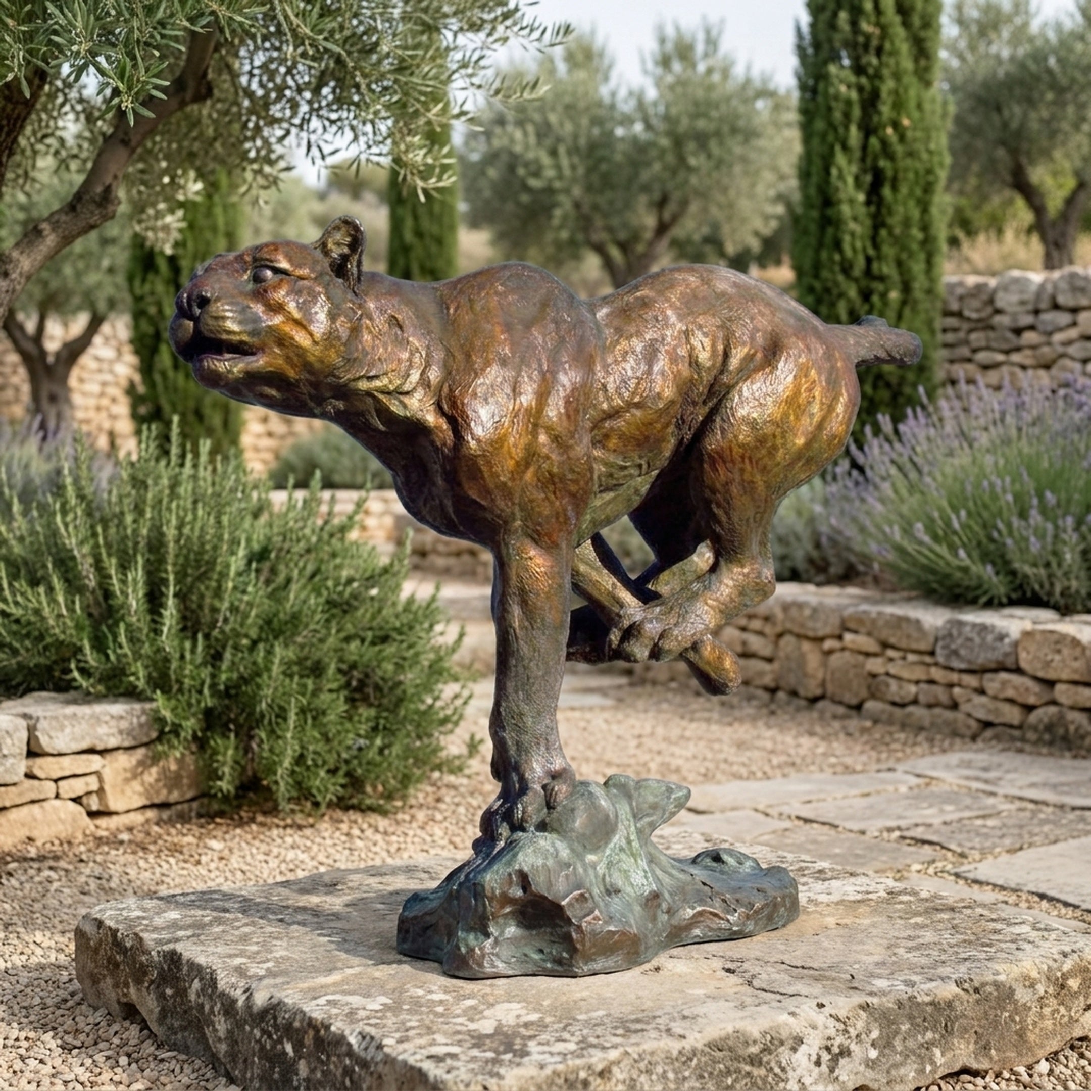 Monumental Traditional Running Cougar Bronze Sculpture by Giant Sculptures in mid-sprint pose with reddish-brown patina, set on a stone courtyard among olive trees.