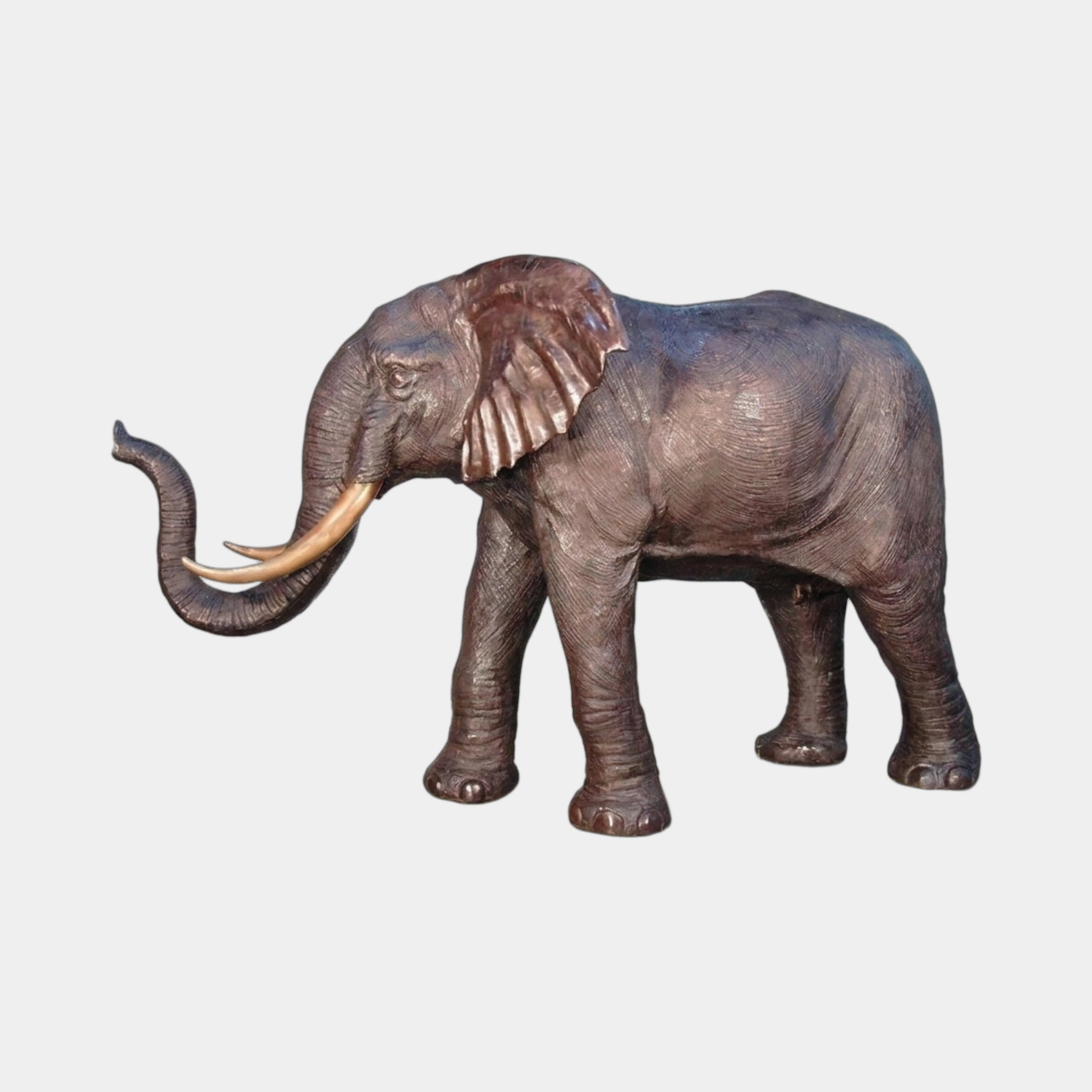 Giant Sculptures Monumental Traditional Walking Elephant Bronze Sculpture 280cm in profile with raised trunk, fanned ears, and ivory-toned tusks on a plain background.