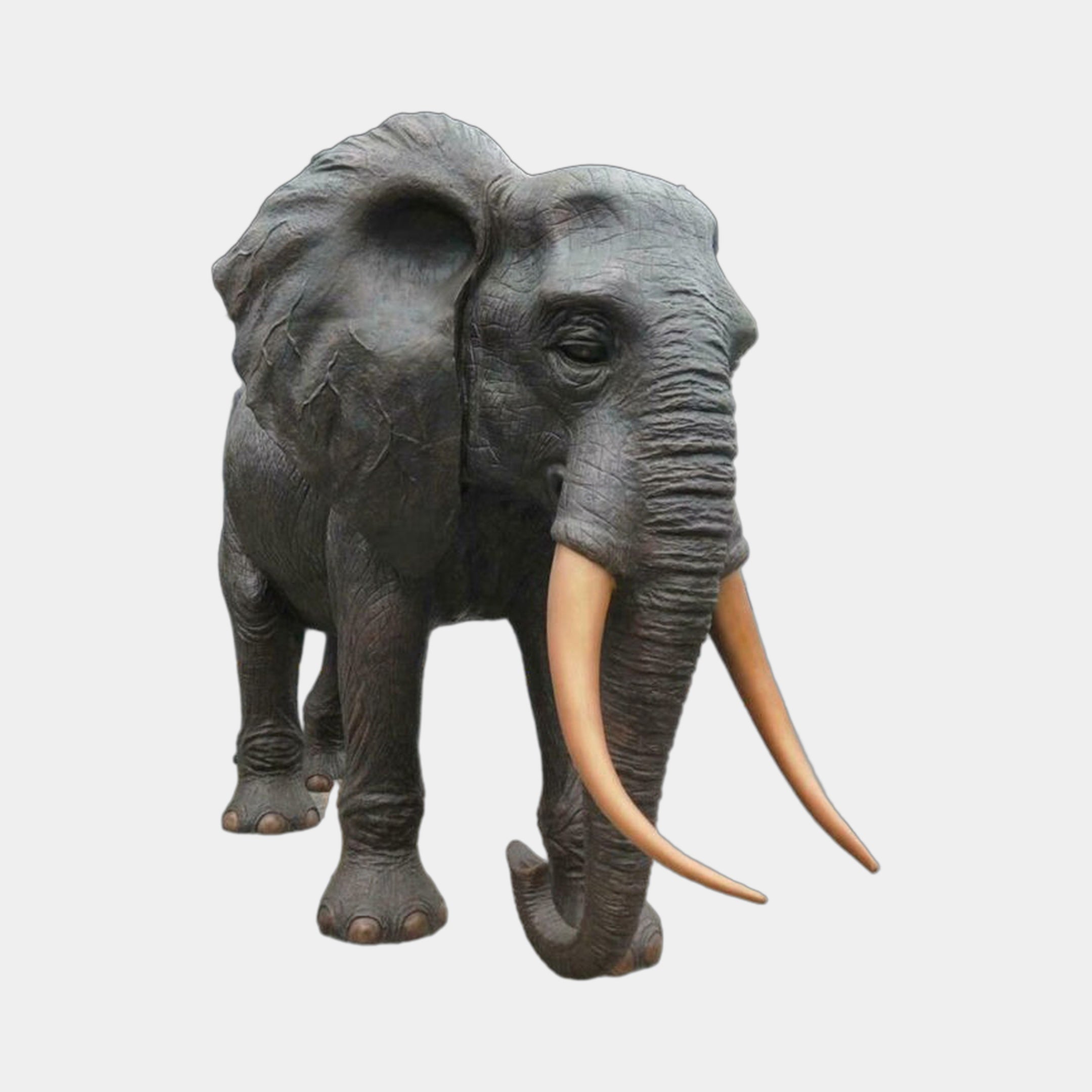 Monumental Traditional Walking Elephant Bronze Sculpture by Giant Sculptures, front view showing dark brown patina, fanned ears, and pale ivory-gold tusks.