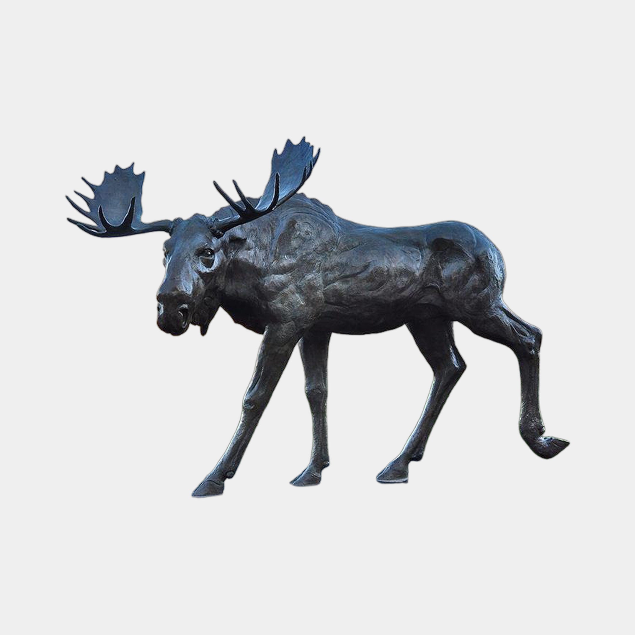 Monumental Walking Moose Bronze Sculpture by Giant Sculptures in dark patina, shown side-on mid-stride with wide antlers, against a plain light background.