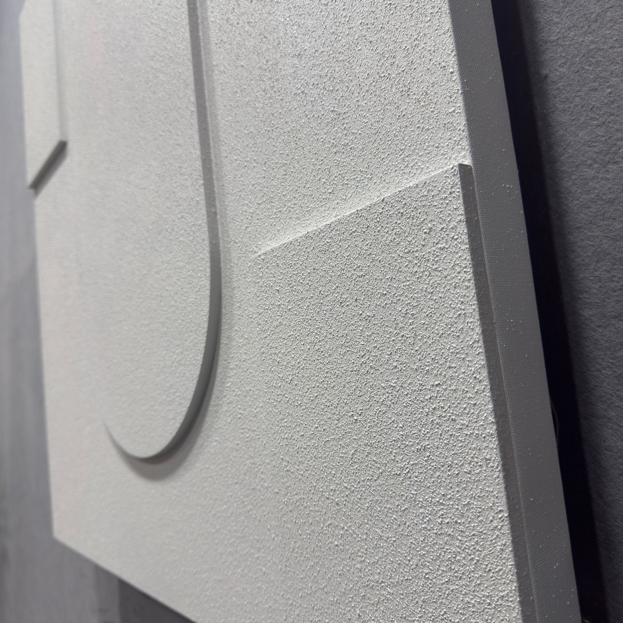 Close-up of the Moro III Triptych White Relief 3D Wall Art by Giant Sculptures, featuring raised geometric shapes with a matte, sandy texture. The lighting casts subtle shadows across its sharp-edged, textured white surface.