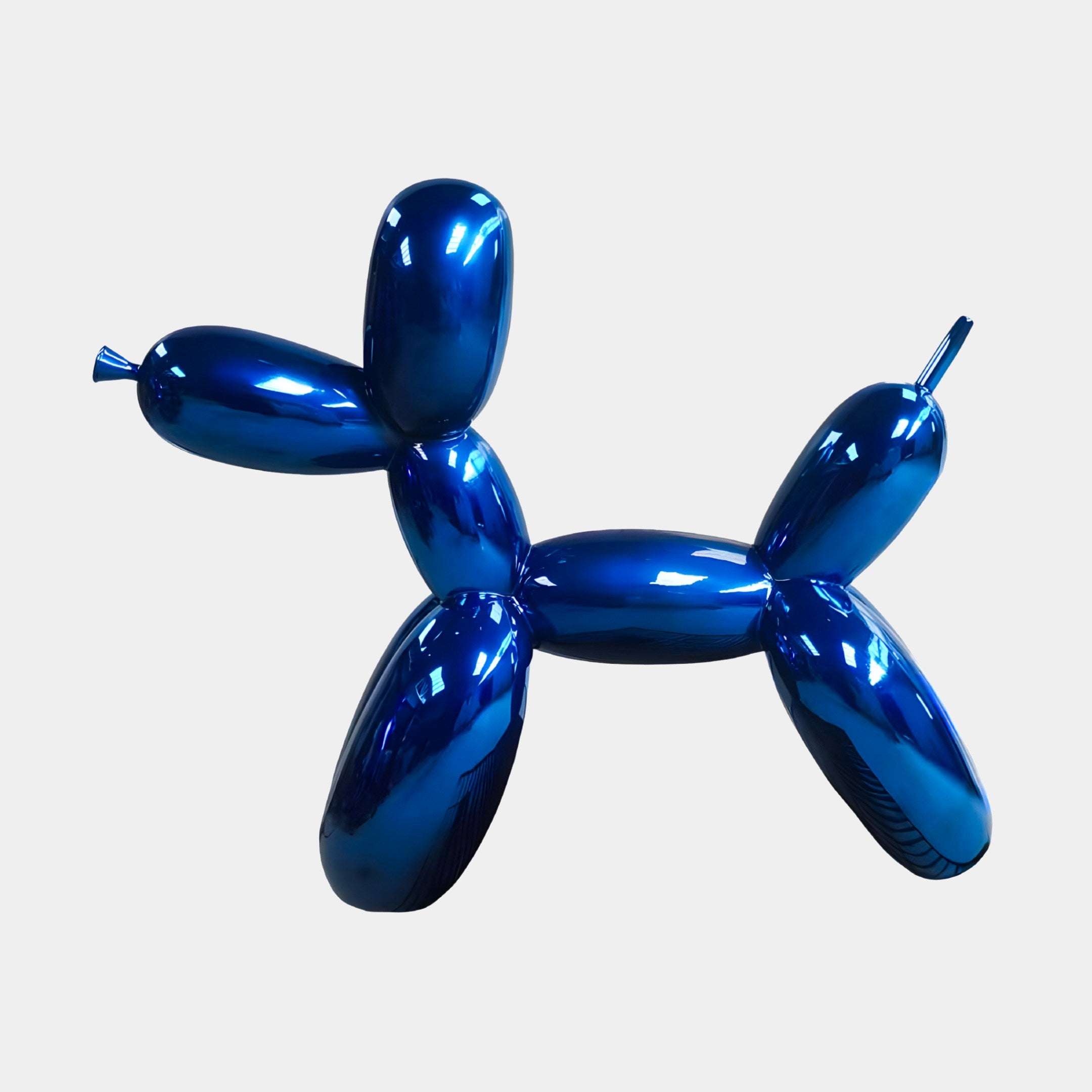 The Ocean Blue Balloon Dog Sculpture by Giant Sculptures, measuring 80cm, elegantly showcases Modern Art with its shiny metallic surface against a white background, reflecting light to highlight its glossy finish and smooth contours.