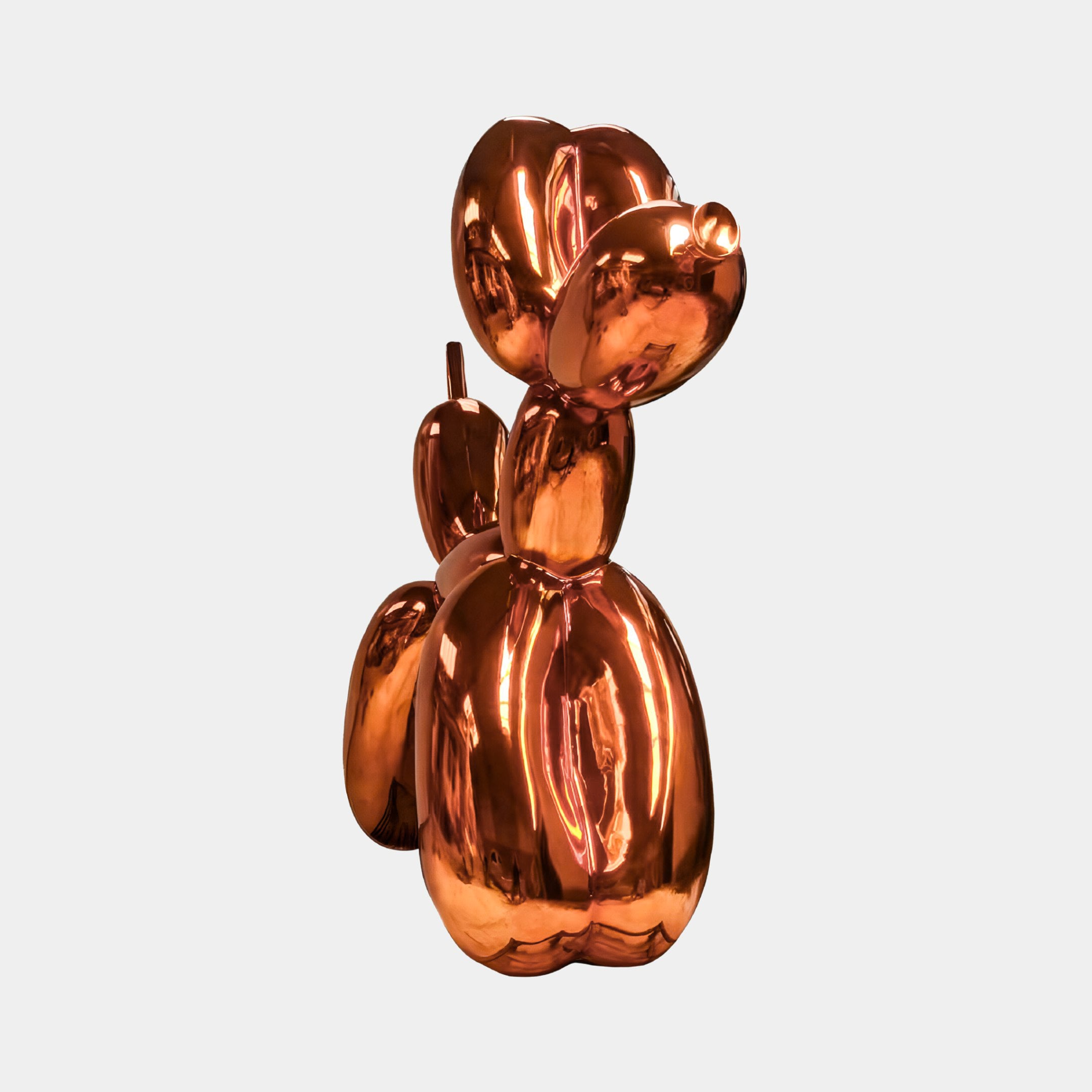 The Giant Sculptures Sunset Orange Balloon Dog Sculpture - 80cm stands upright against a light gray background, showcasing a shiny, metallic finish that reflects modern art and contemporary style.