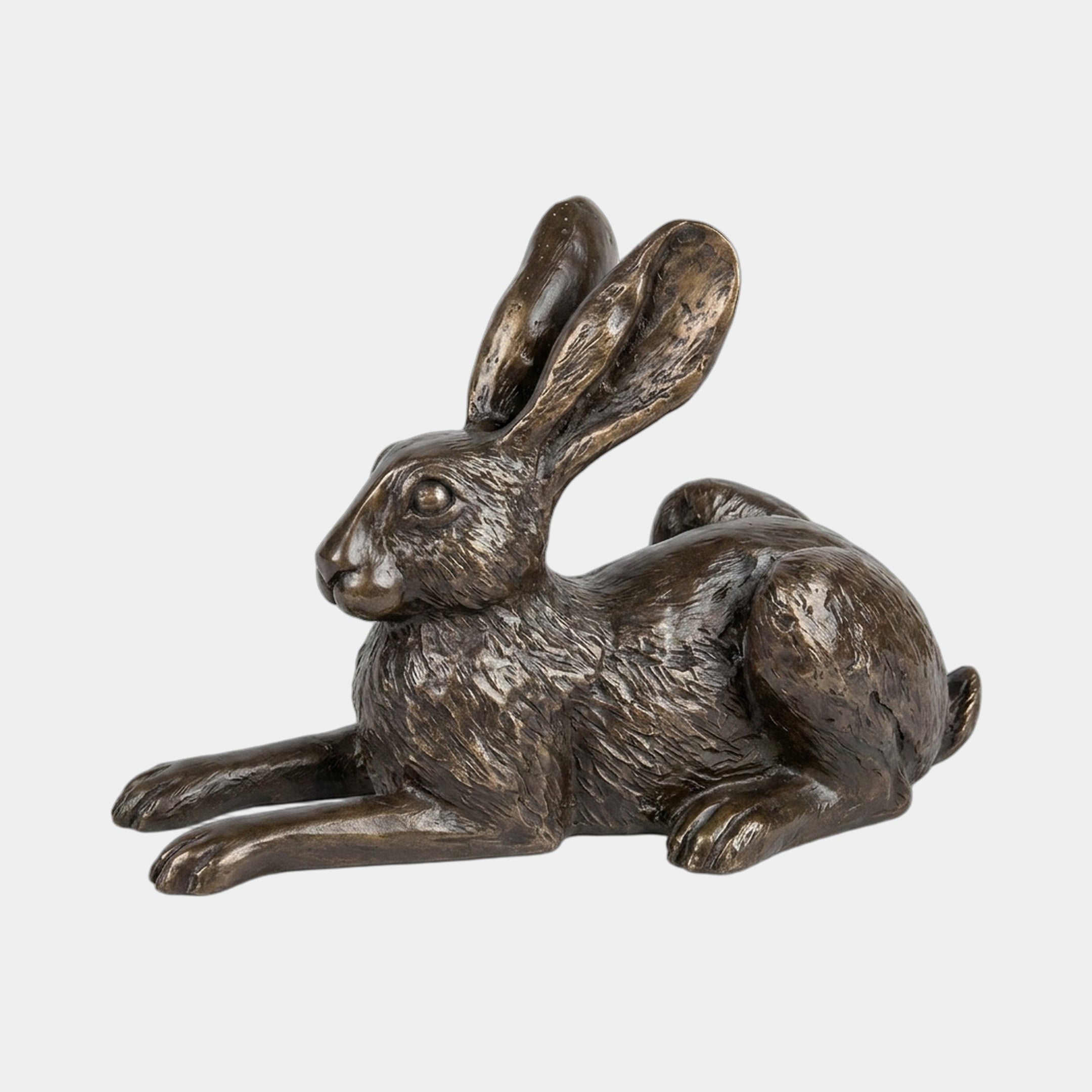 Traditional Lying Hare Bronze Sculpture by Giant Sculptures, 25cm, shown in side profile with ears upright and legs stretched, warm brown patina against a plain background.