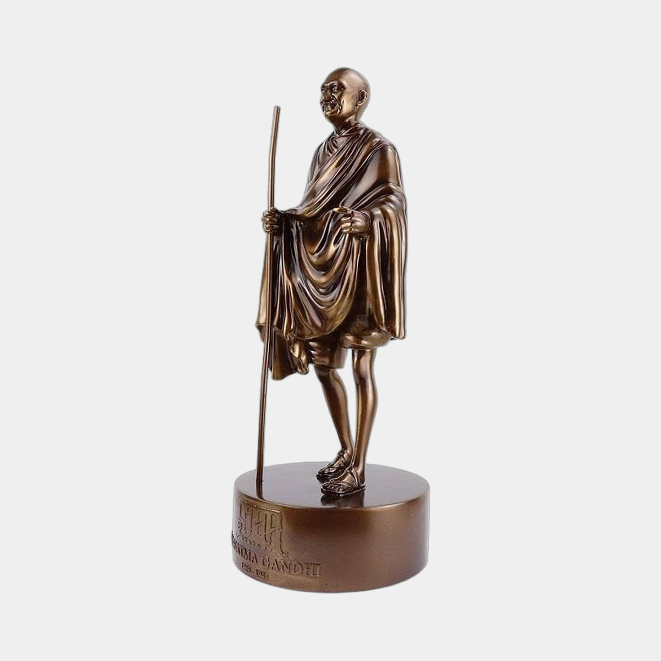 Traditional Standing Gandhi Figure Bronze Statue by Giant Sculptures, 30cm, shown in a walking pose with staff and draped shawl on an inscribed cylindrical base.