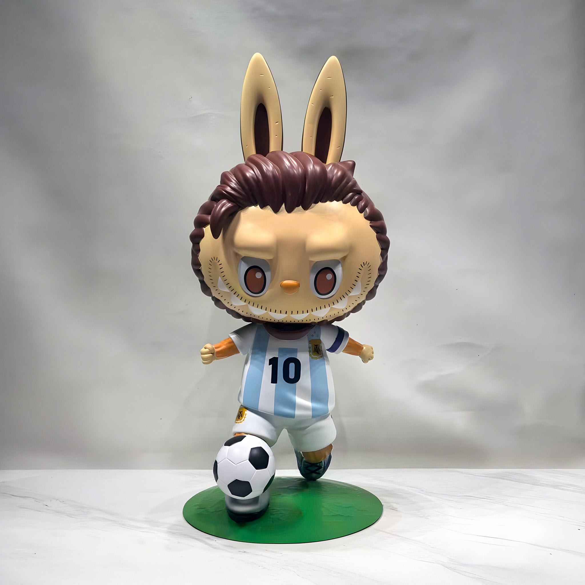 Labubu style football character wearing an soccer jersey, standing on a white surface with a grey background.