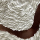 Close-up of Giant Sculptures' Riverine Flow Pearl White Textured Triptych Wall Art, featuring densely layered white circular shapes on a brown background for a wave-like, textured effect.