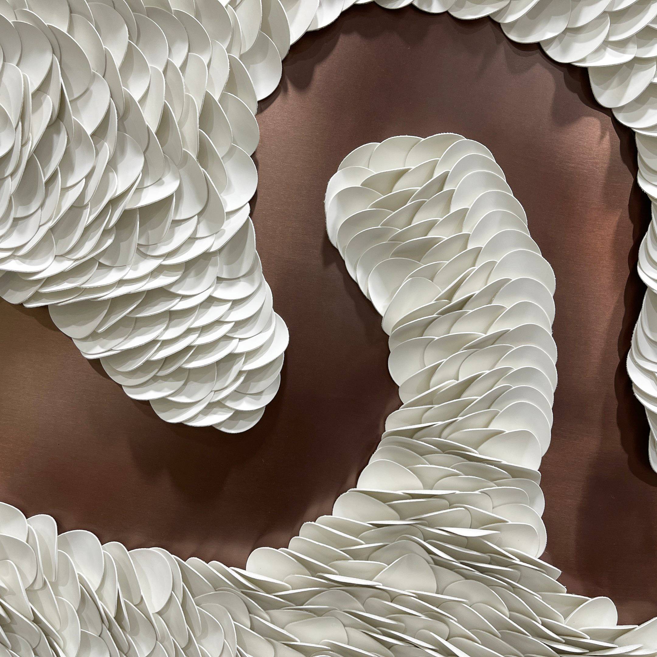 The Riverine Flow Pearl White Textured Triptych Wall Art by Giant Sculptures features layered, flowing white ovals on a brown background, creating a striking modern design reminiscent of feathers or scales.