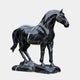 The Standing Horse Black Marble Outdoor Sculpture by Giant Sculptures, measuring 220cm, showcases sleek artistry with its glossy black finish and marble-like white streaks. The detailed sculpture captures the horses muscular form and flowing mane, standing elegantly on a matching base.