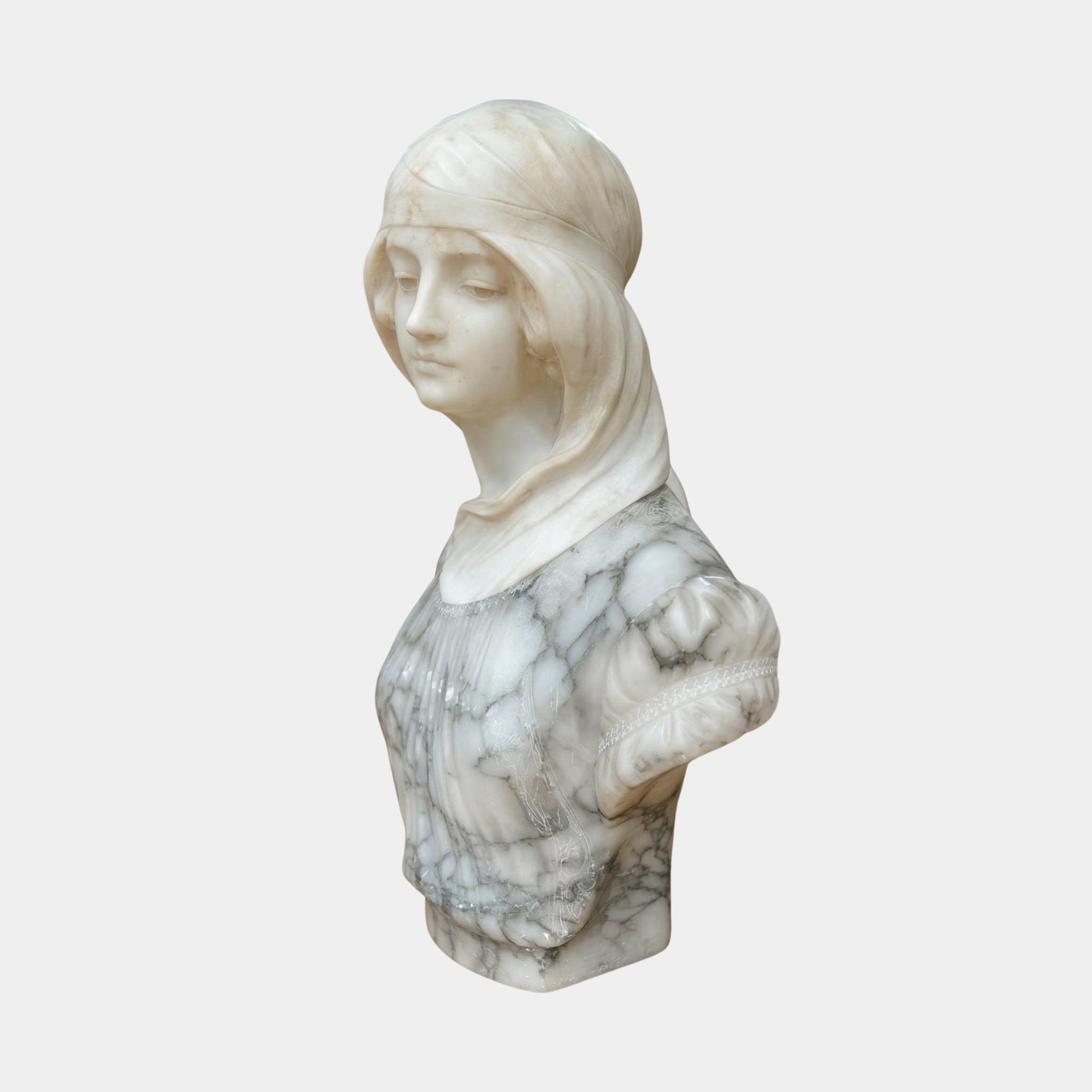 The Classical Maiden Marble Bust - 60cm by Giant Sculptures features a white marble woman with gray veining, a headscarf, detailed face, textured garment, and one missing arm.