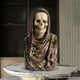 The Giant Sculptures Memento Mori Skull Marble Bust Sculpture (55cm) features a hooded skeleton design, displayed on a round marble table with striped and paneled walls in the background.