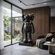 Rear view of the Giant Sculptures Black Stone Iconify Standing Sculpture 70cm on a black plinth in a modern living room with walnut slat wall and garden view.