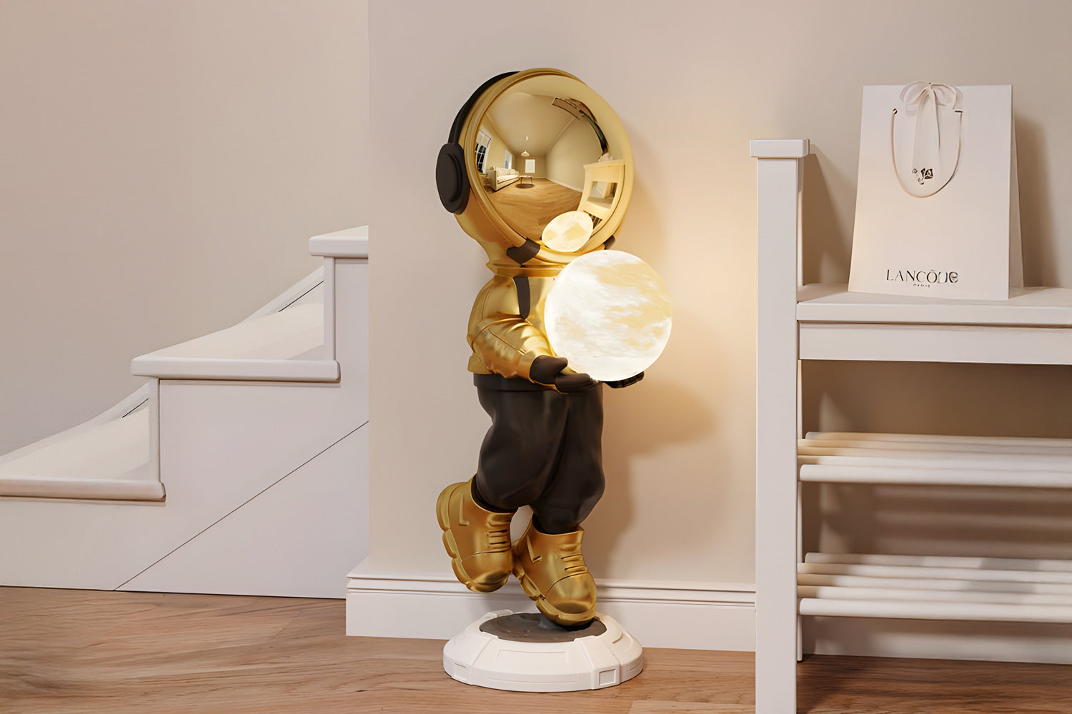 A golden astronaut sculpture leans against a wall, holding a glowing, spherical light resembling the moon. Its positioned near a staircase with a shopping bag and shelves nearby, casting a warm glow.