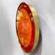 Side-angle view of the Galaxia Sun Crystal Porcelain LED Wall Art by Giant Sculptures, showing the domed amber and red sun motif within a brushed gold ring frame.